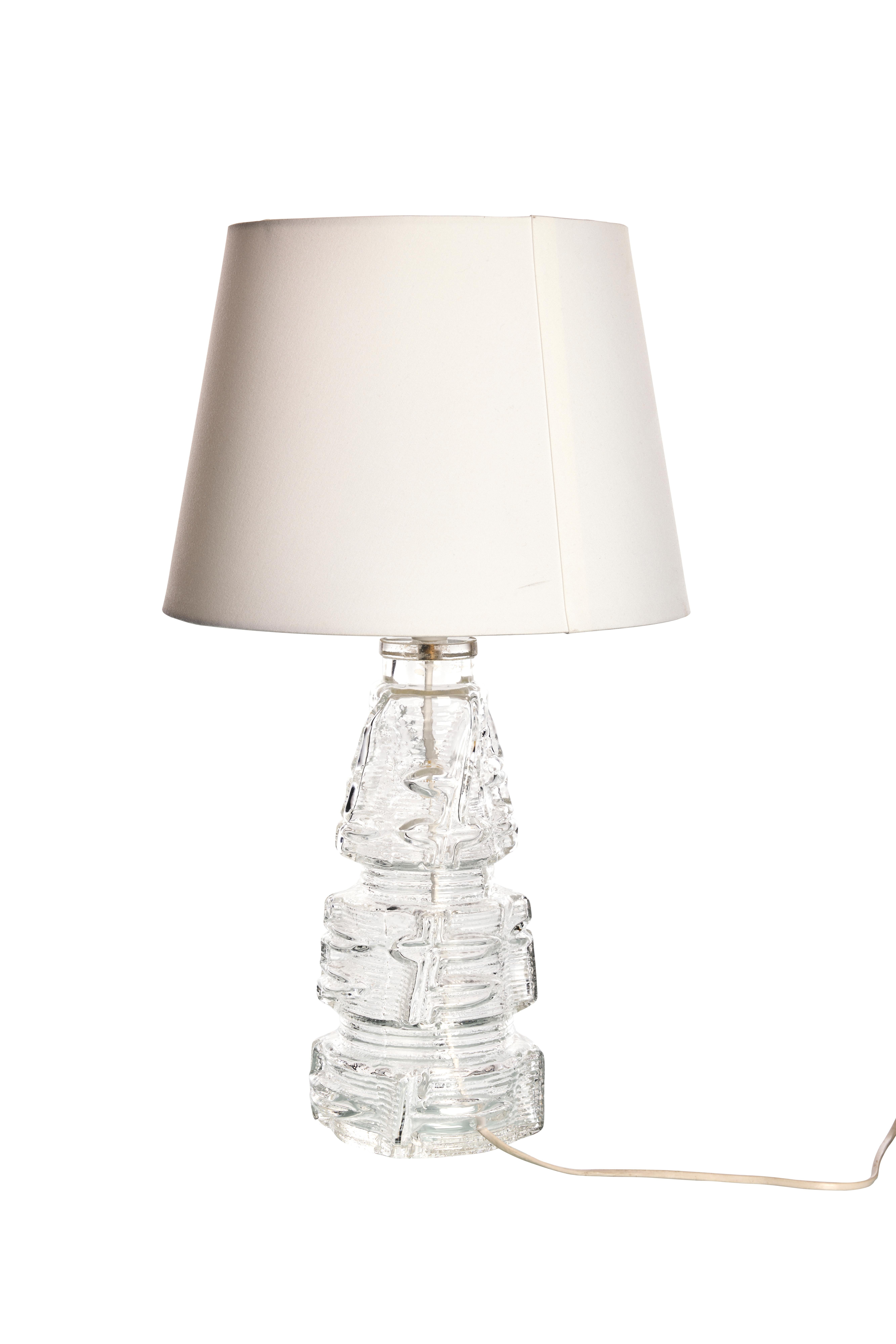 Lampe de table sculpturale en verre transparent par Pukeberg, 1970

Cette lampe de table étonnante, fabriquée par Pukeberg dans les années 1970, est dotée d'une base sculpturale en verre transparent avec un design texturé et stratifié. Le travail
