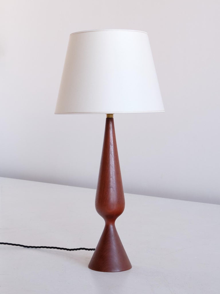 This striking table lamp was produced in Denmark in the 1960s. Sculptural organic lamp body in solid teak wood. The new tapered drum shade was custom made in an ivory matte fabric.

Rewired, new bulbholder and 220 V European plug, bayonet mount
