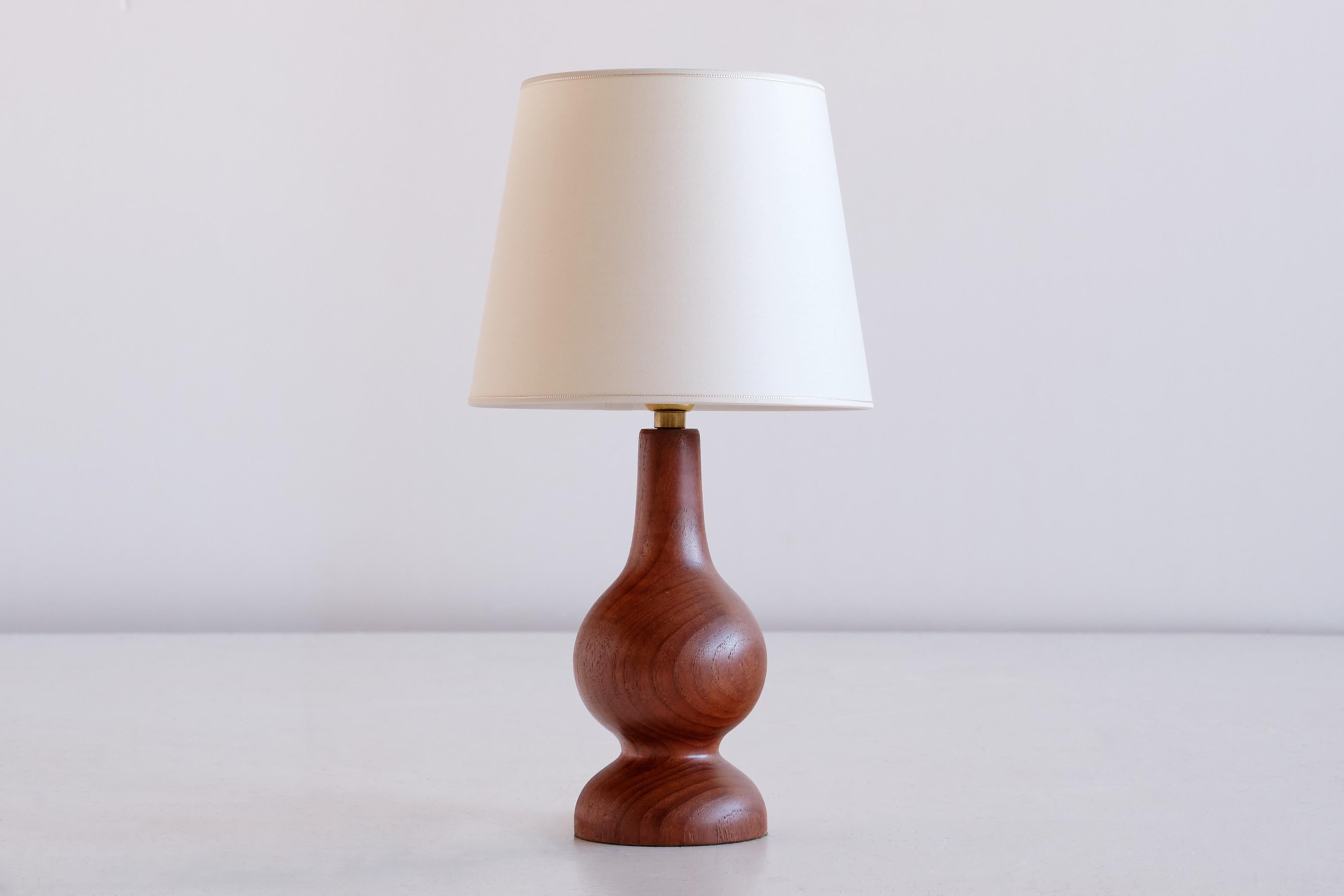 This striking table lamp was produced in Denmark in the 1960s. Sculptural organic lamp body in solid teak wood. The new tapered drum shade was custom made in an ivory matte fabric.

Rewired, new bulbholder and 220 V European plug, bayonet mount