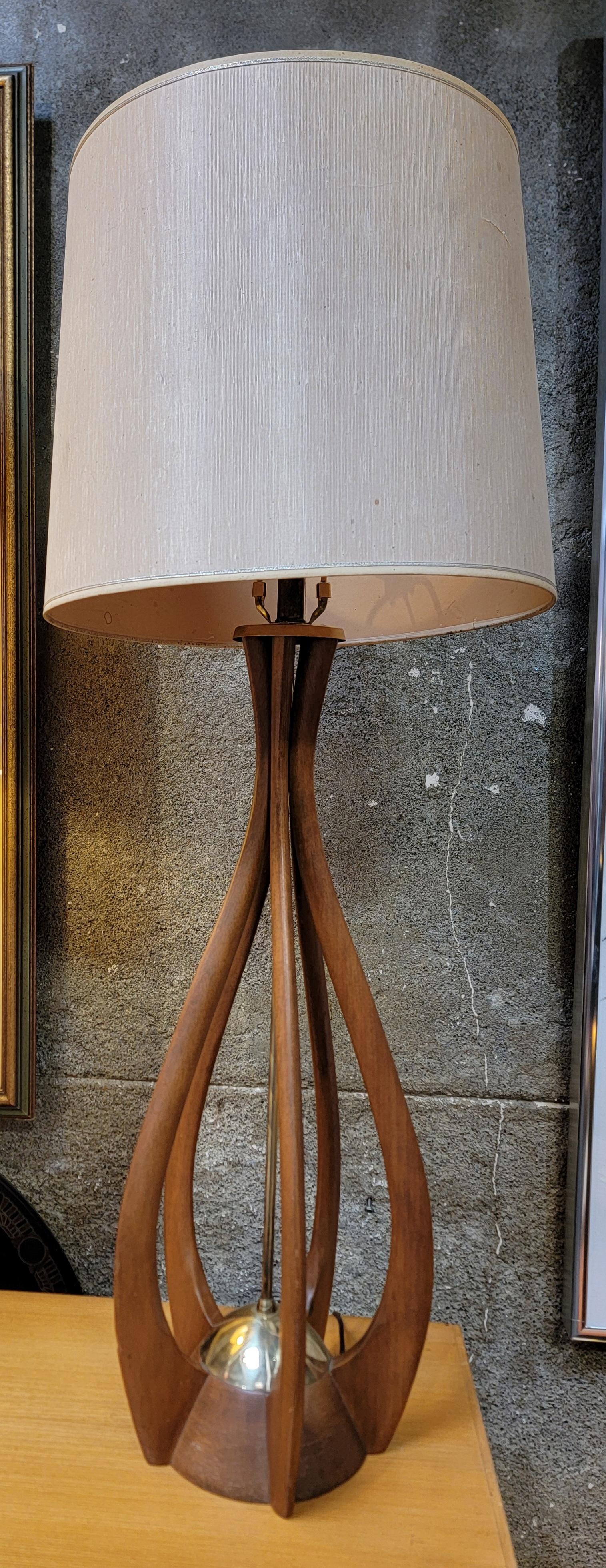 A sculptural walnut table lamp in the manner of Modeline, attributed to John Keal. 

Height to finial 40.75 in
Height to base of socket 26.5 in.

Shade is not included, worn and tattered.