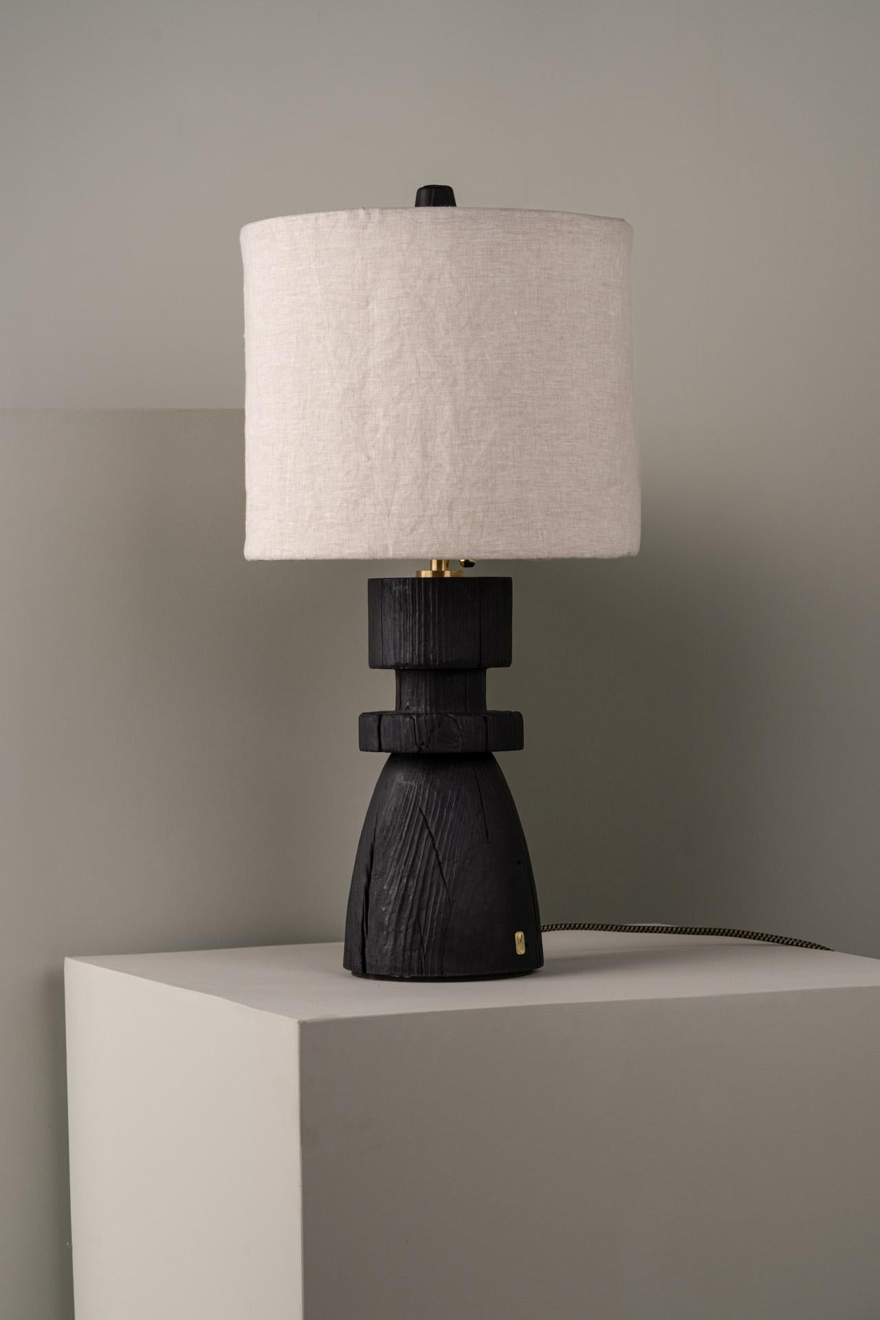 MEZQUITE table lamp was designed for the De Palo collection by Mexican artist Isabel Moncada.

When burnt using the Japanese technique Shou sugi ban, the wood grains become apparent and the cracks randomly appear in the solid trunk. Mezquite's