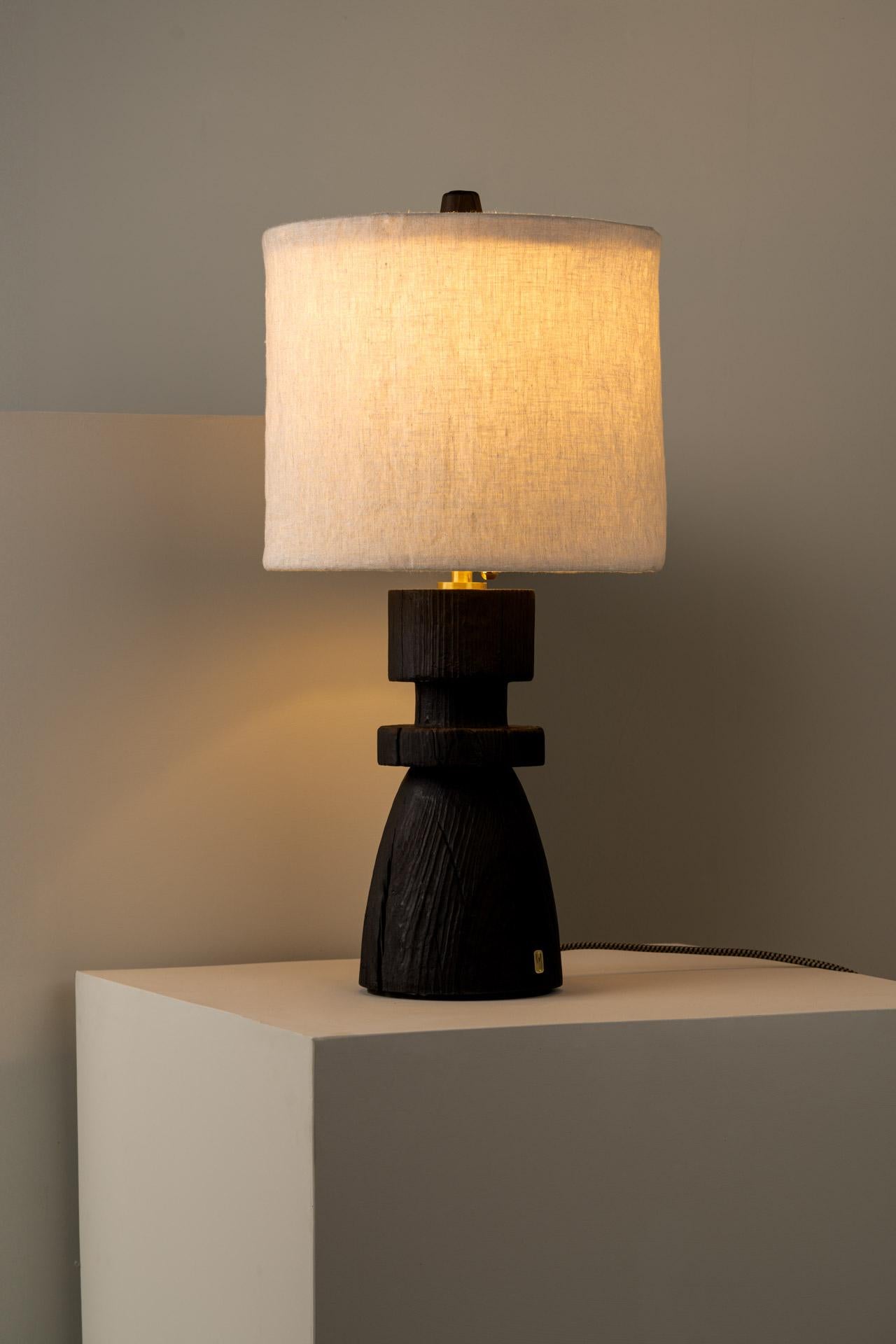 MEZQUITE table lamp was designed for the De Palo collection by Mexican artist Isabel Moncada.

When burnt using the Japanese technique Shou sugi ban, the wood grains become apparent and the cracks randomly appear in the solid trunk. Mezquite's