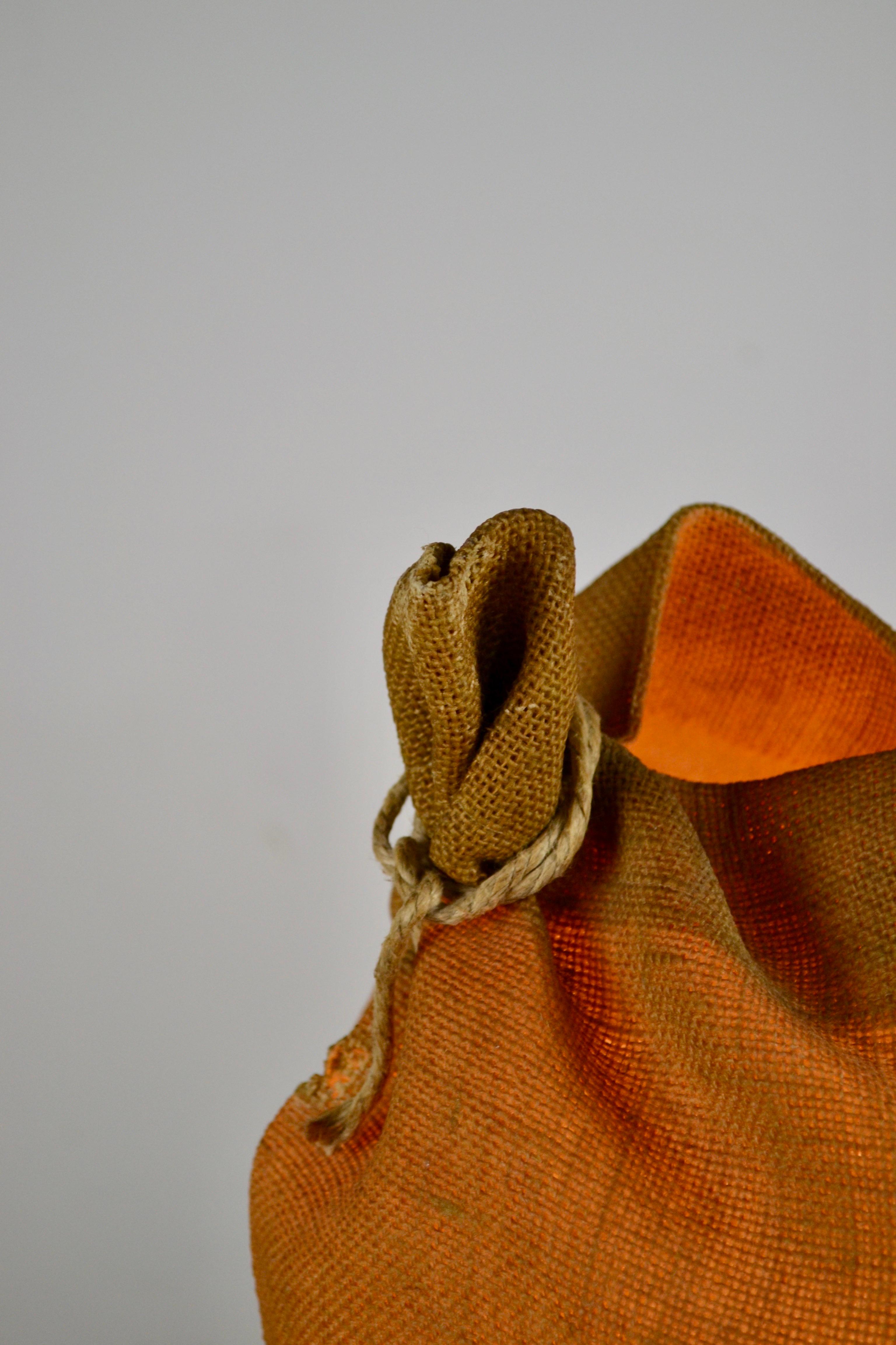 Una rara lampada da tavolo francese degli anni '60 che trascende la funzione per diventare un oggetto scultoreo. Un sacco di caffè di Rio de Janeiro in juta viene catturato in resina, conservando la sua forma accartocciata ed evidenziando la qualità