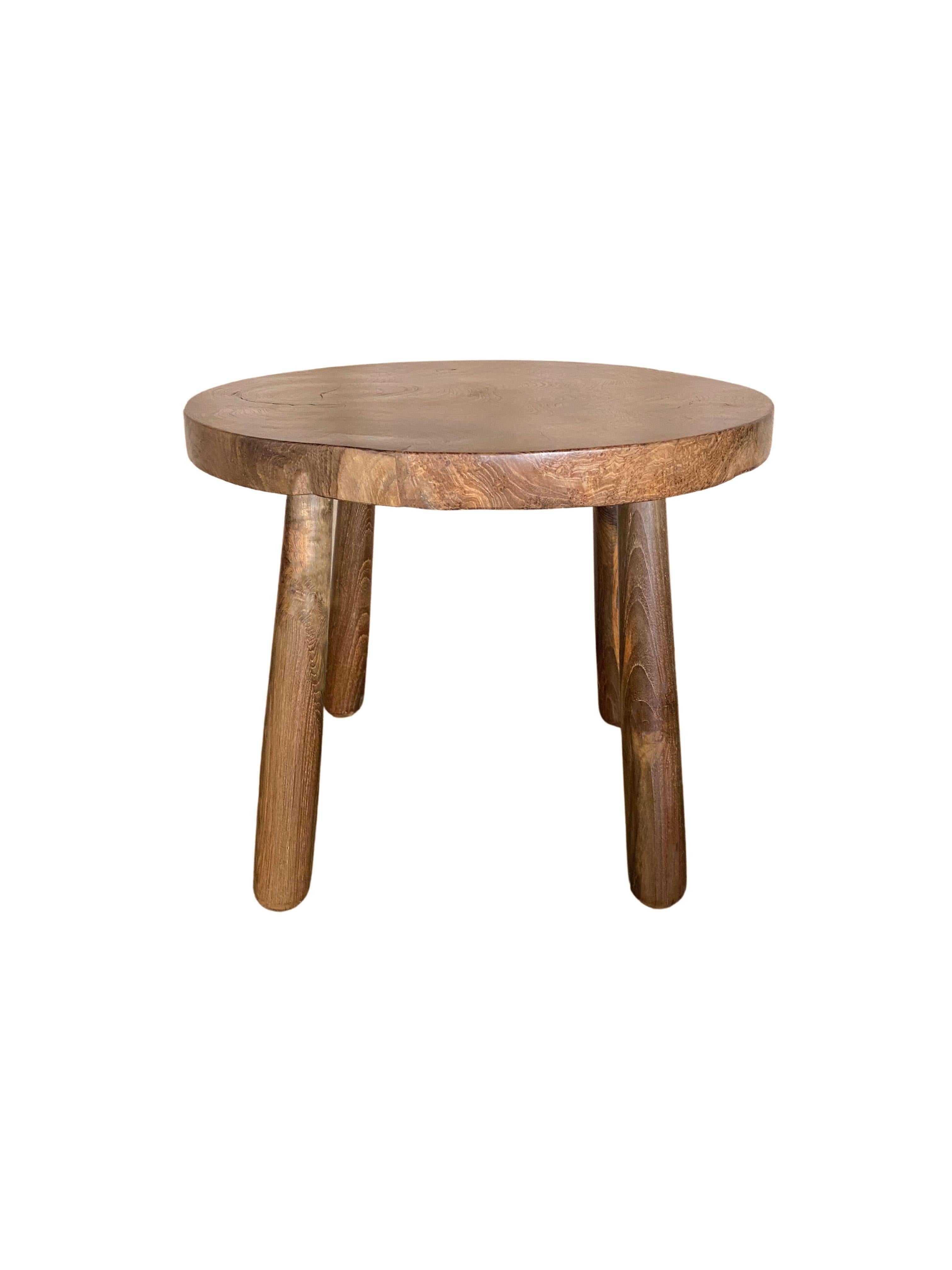A sculptural teak wood side table which features an incredible teak burl wood patterning on the table top. Carved from a single block of wood to find teak patterning as intricate as this is hard to come by. The table feature four curved legs that