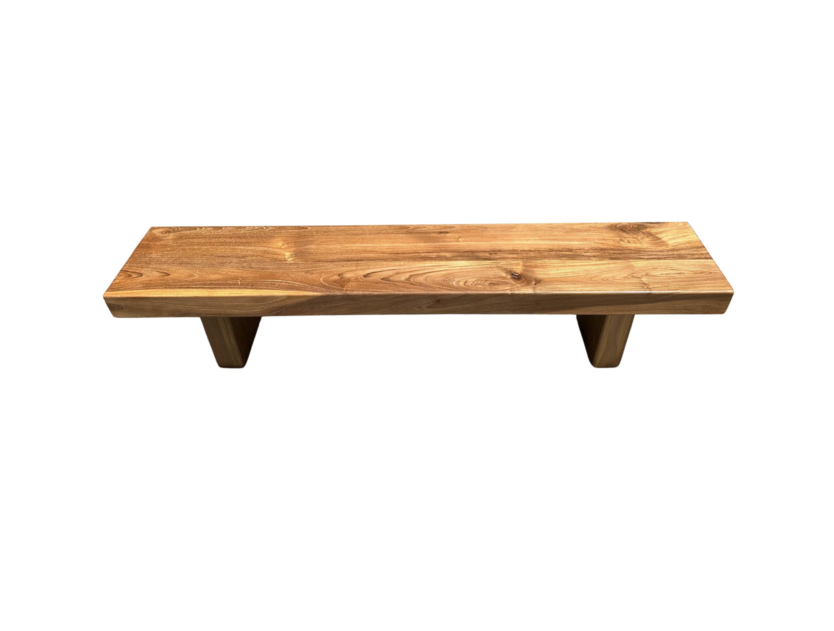 The bench was sculpted from solid teak wood. The wood used to create this bench is reclaimed, sourced from old pillars of traditional Java Houses, from the island of Java, Indonesia. It features a natural finish with stunning wood contours and