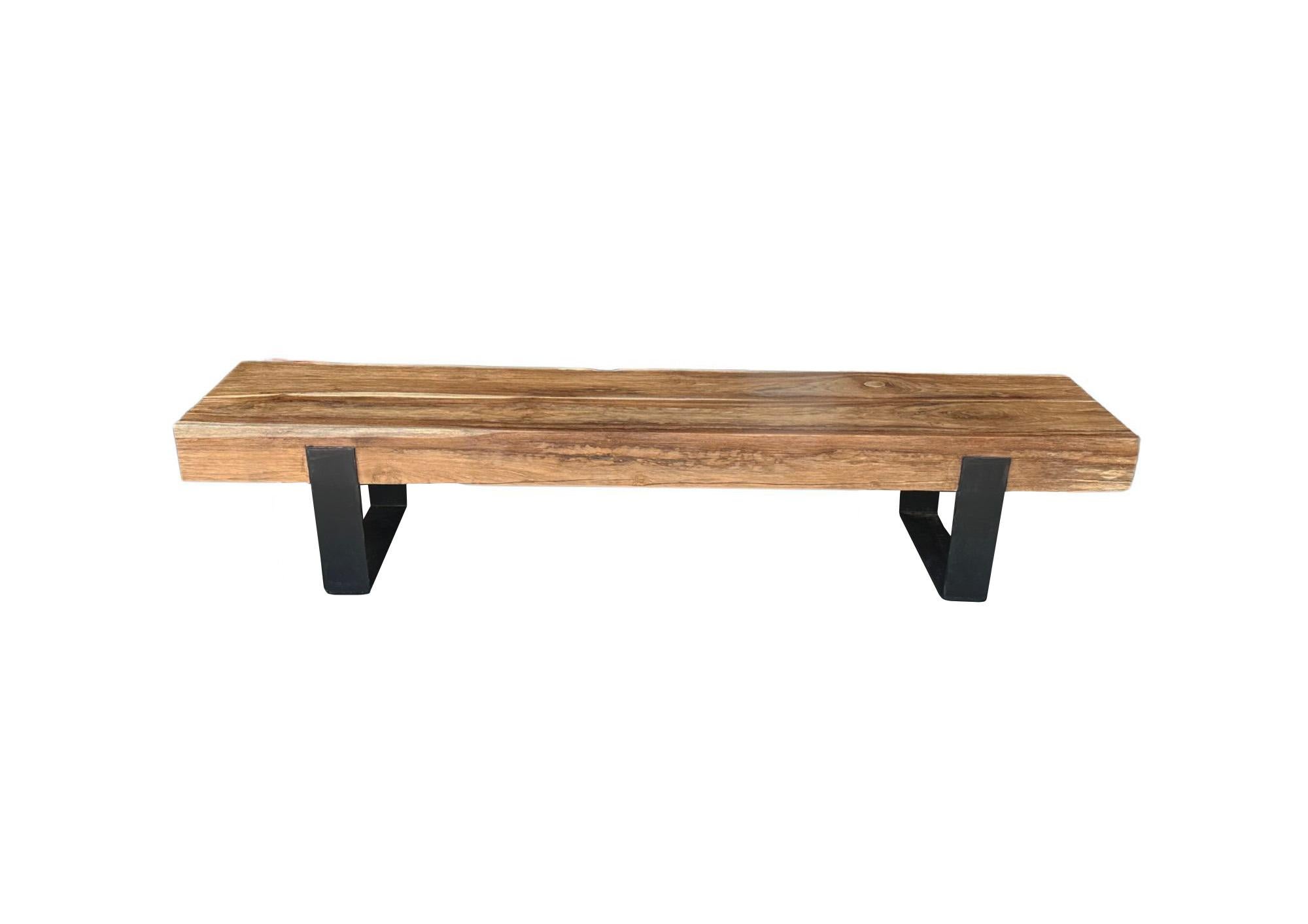 A sculptural Teak wood bench crafted from solid teak beams. Supported by 2 industrial steel legs. This bench has a wonderful mix of wood textures and shades. The perfect object to bring warmth to any space. 




 