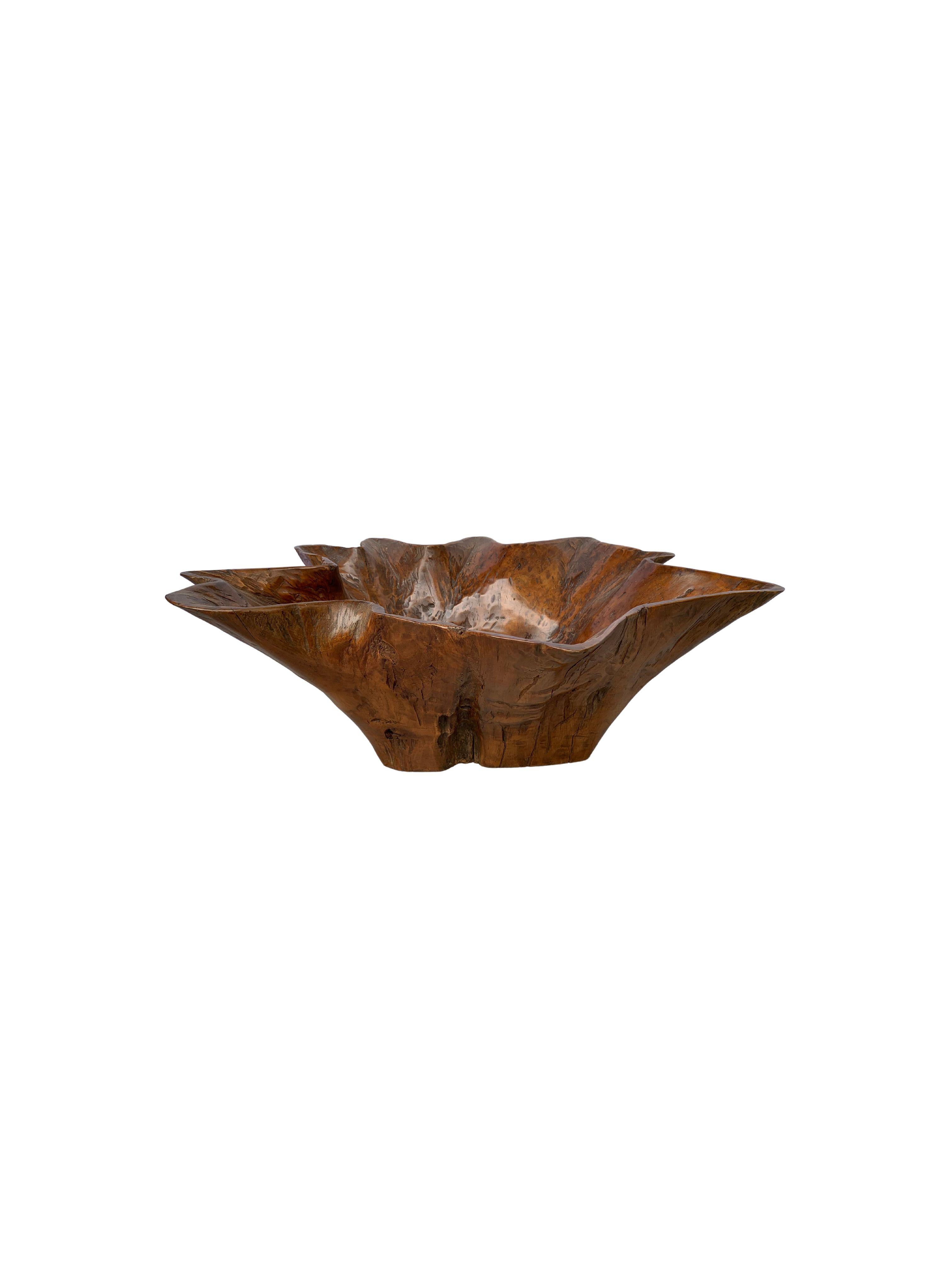 A teak wood bowl crafted on the island of Java, Indonesia. The bowl was cut from the part of the tree where the main trunk branches out. A wonderful piece of craftsmanship leading to a wonderfully shaped bowl. 

