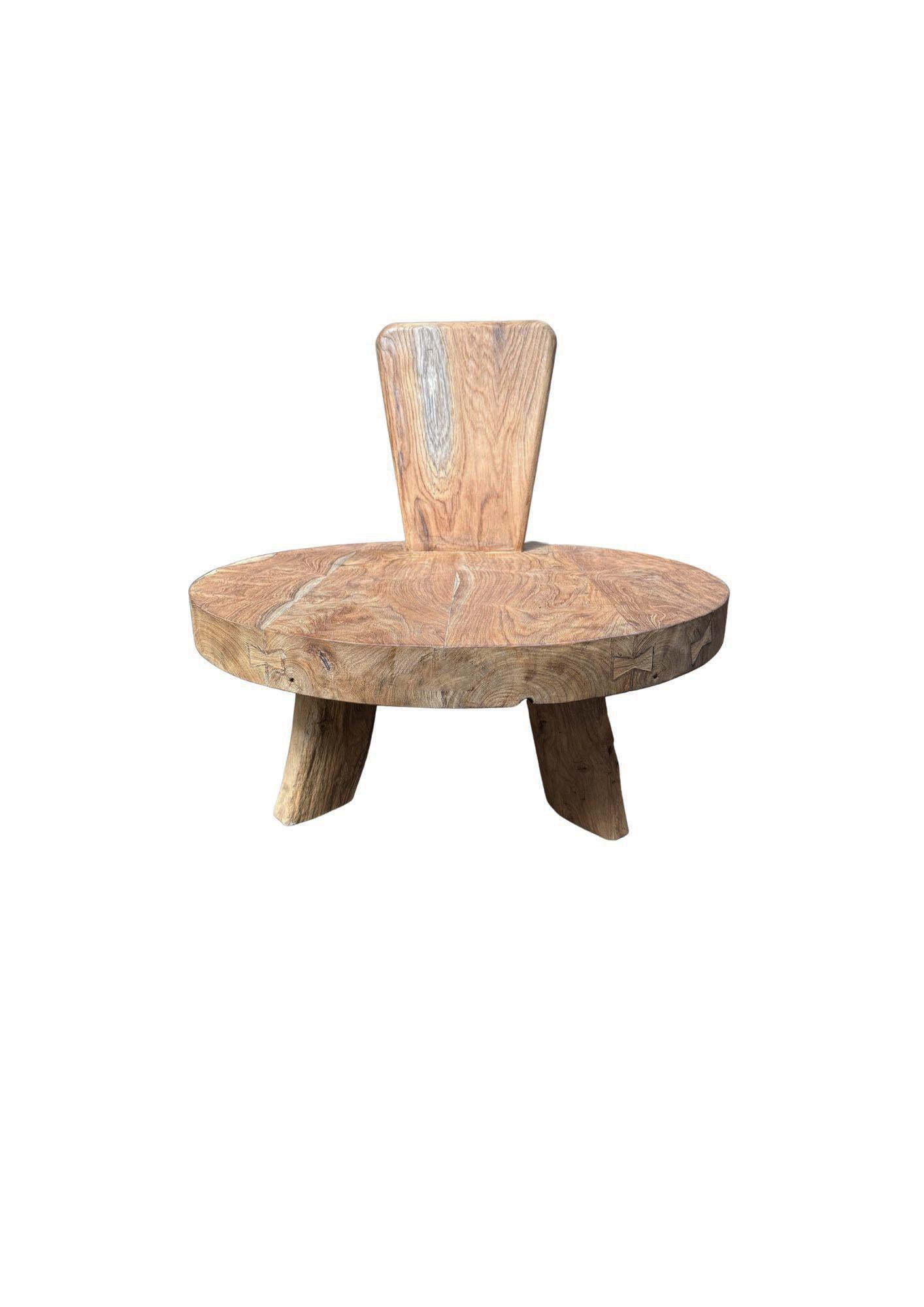 D'une forme audacieuse et d'une texture riche, cette chaise sculpturale est fabriquée à la main à partir de bois de teck massif, mettant en valeur la beauté organique de son grain naturel. L'assise circulaire généreuse et le dossier très incliné