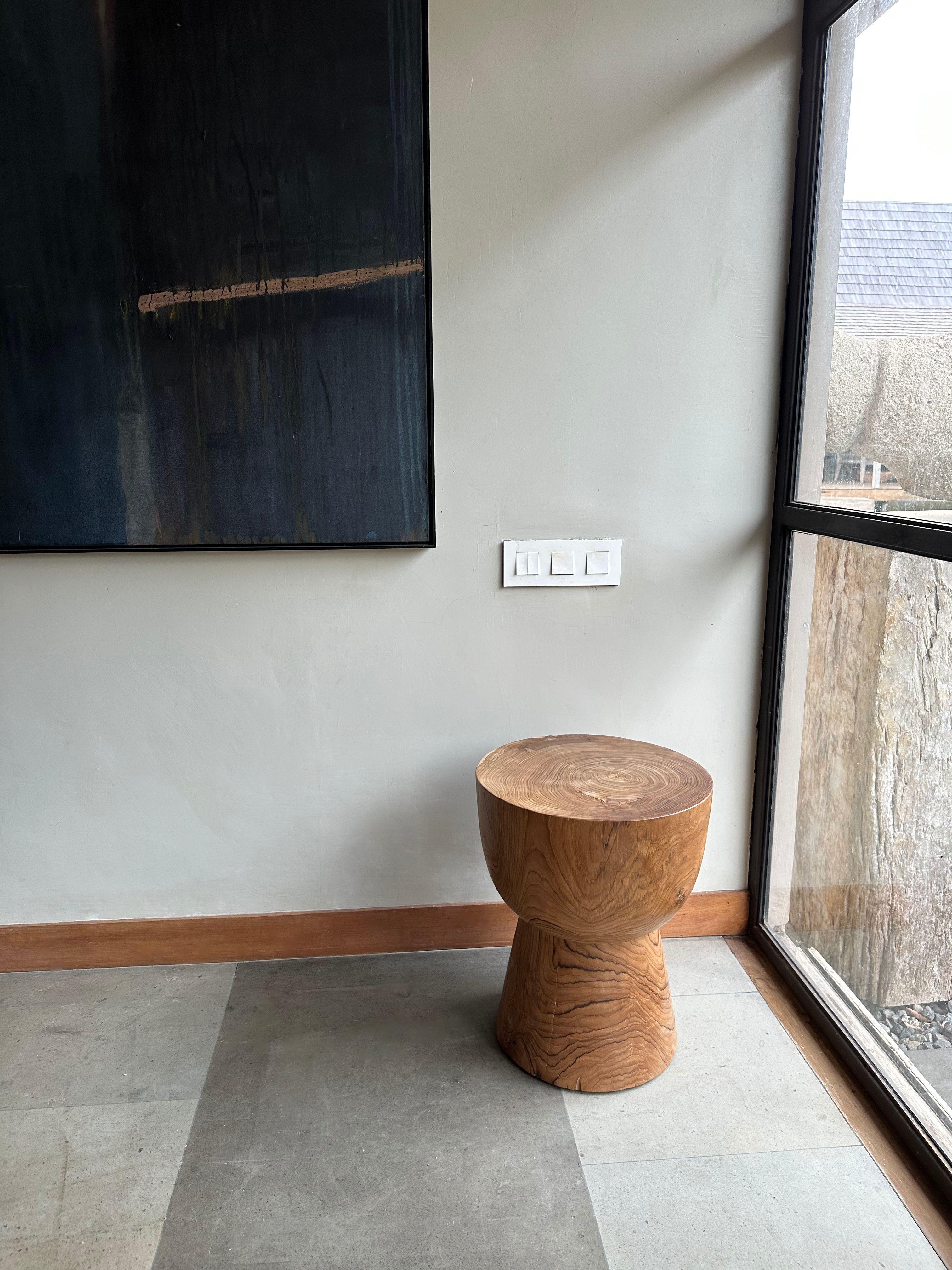 A wonderfully sculptural side table crafted from Teak Wood. Its subtly curved edges add to its charm. This table features a wonderful array of wood textures and shades. The perfect object to bring warmth to any space.