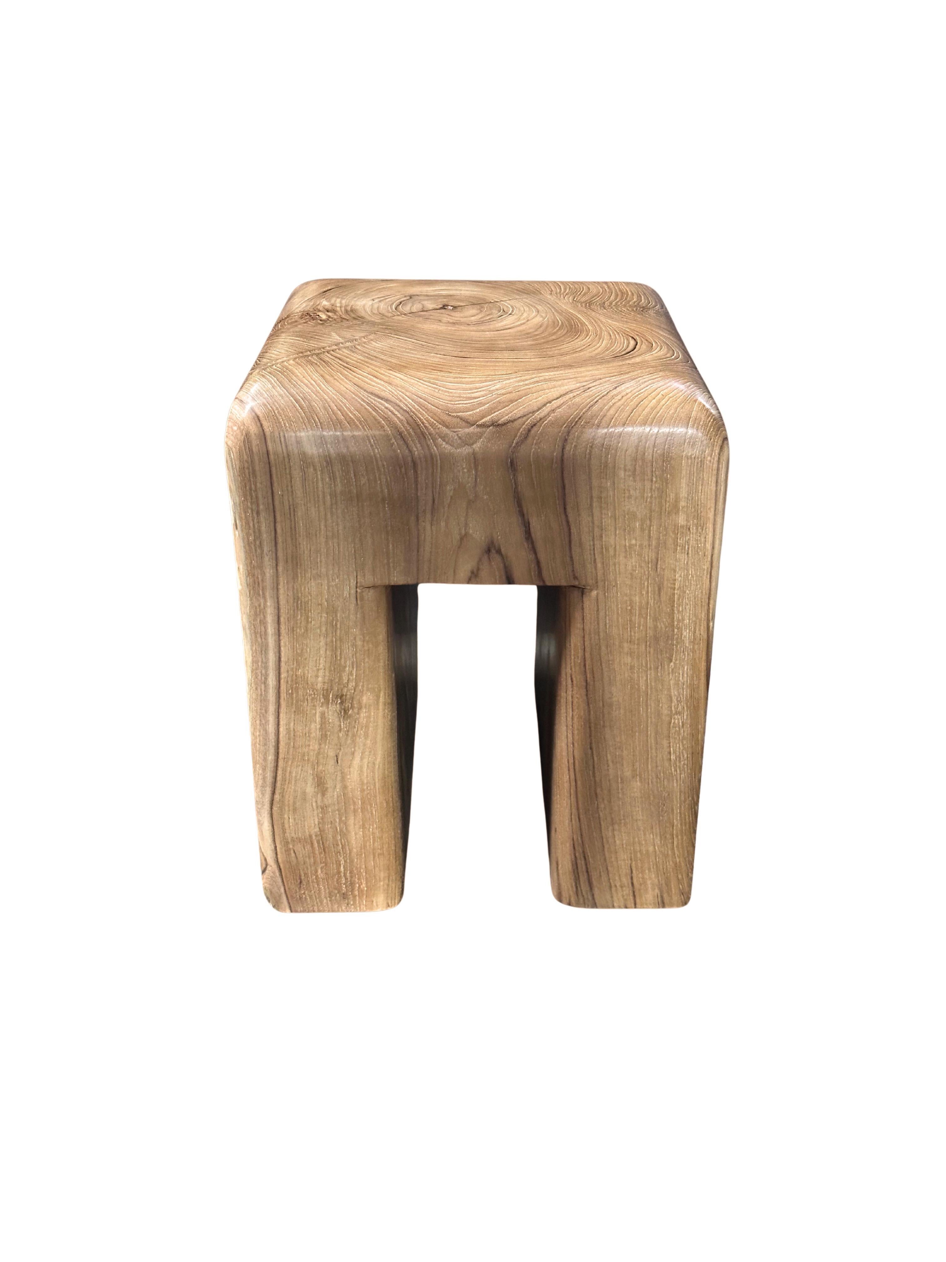 Uno sgabello in legno di teak meravigliosamente organico e scultoreo, ricavato da un unico blocco di legno. Il contrasto tra i dettagli curvilinei e le texture e le tonalità del suo legno danno vita a uno sgabello molto elegante. 