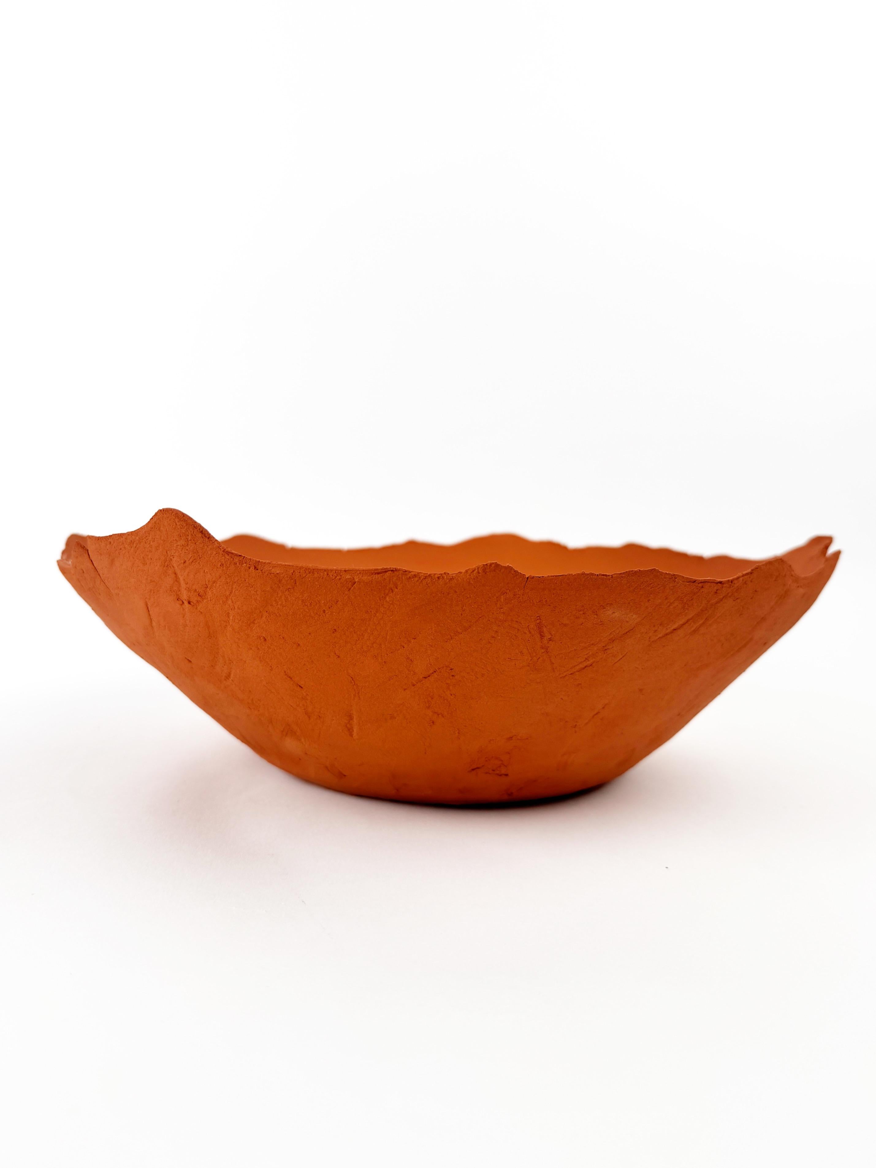 Este cuenco escultórico de cerámica de terracota es un objeto de diseño único, hecho a mano, de gres rojo ricamente pigmentado. Su forma irregular y orgánica y su superficie cruda y texturizada evocan la belleza de las formaciones naturales de la