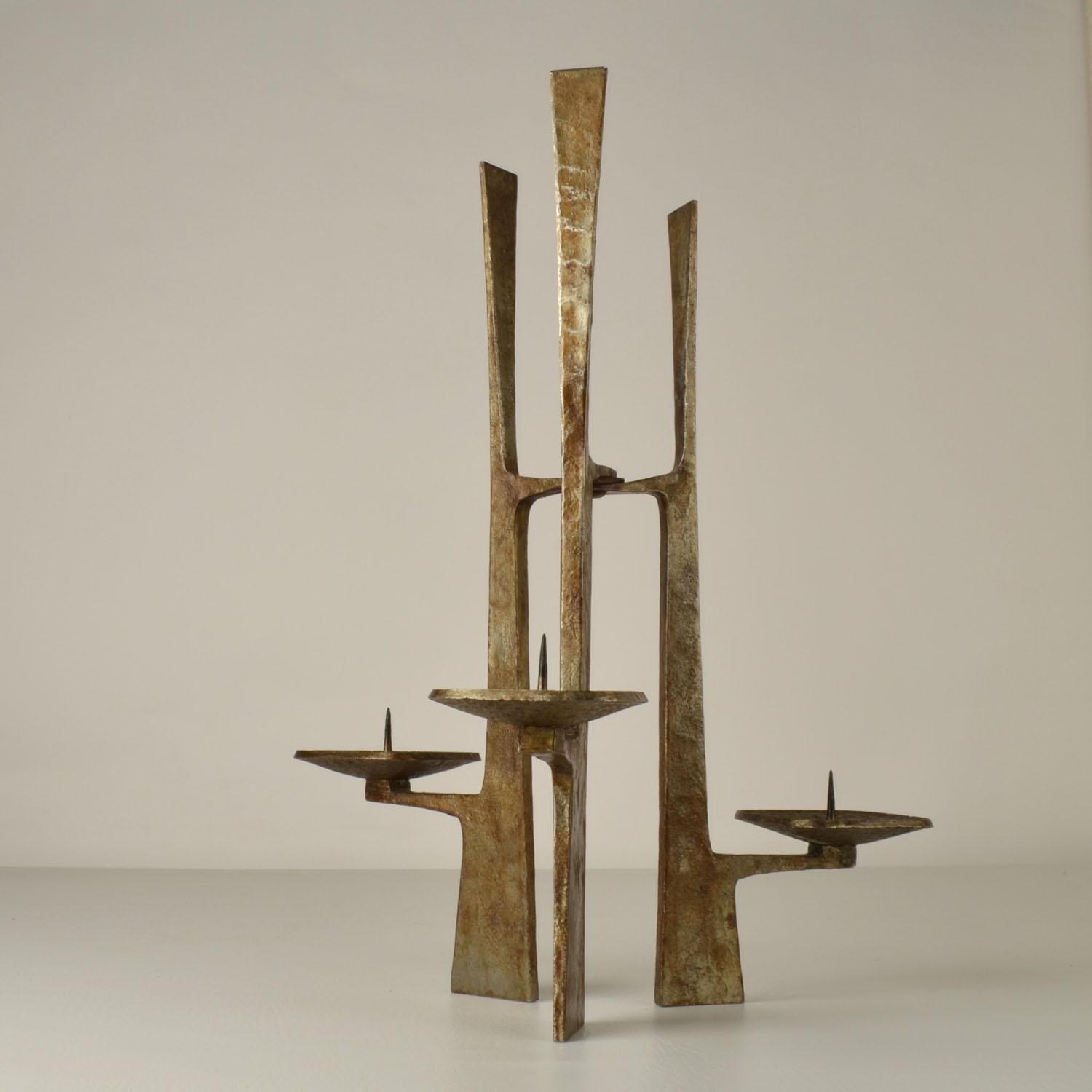 Ce candélabre sculptural en acier forgé fabriqué dans les années 1960 a une allure monumentale et architecturale. Il possède trois bras et convient aux bougies d'un diamètre de 4 à 5 cm. L'œuvre est signée par l'artiste.
