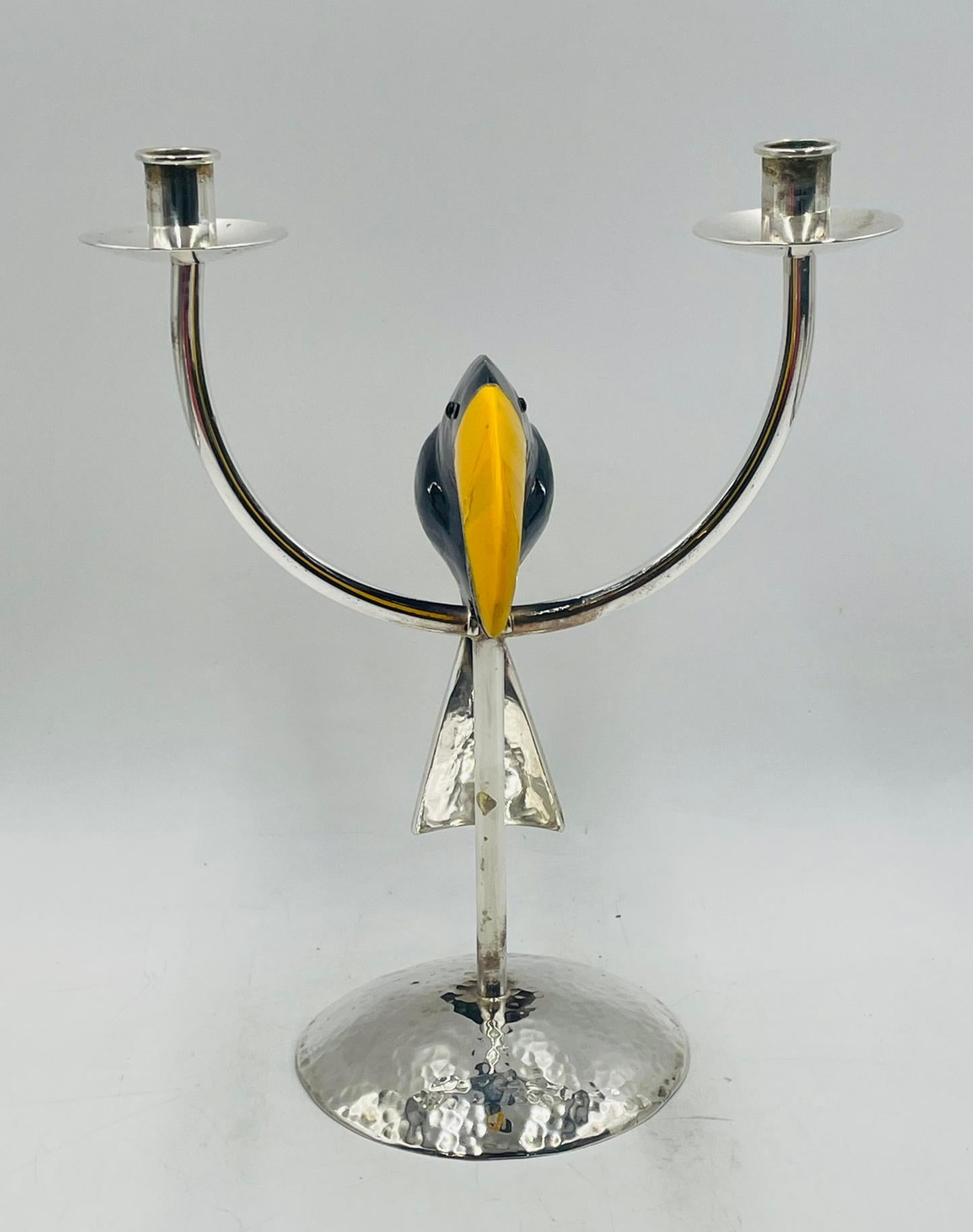 A bold and whimsical two-light candle holder in the style of Emilia Castillo for Los Castillo, crafted in hammered copper with a silver-plated finish. The sculptural design features a striking toucan figure as the central motif, with a tessellated