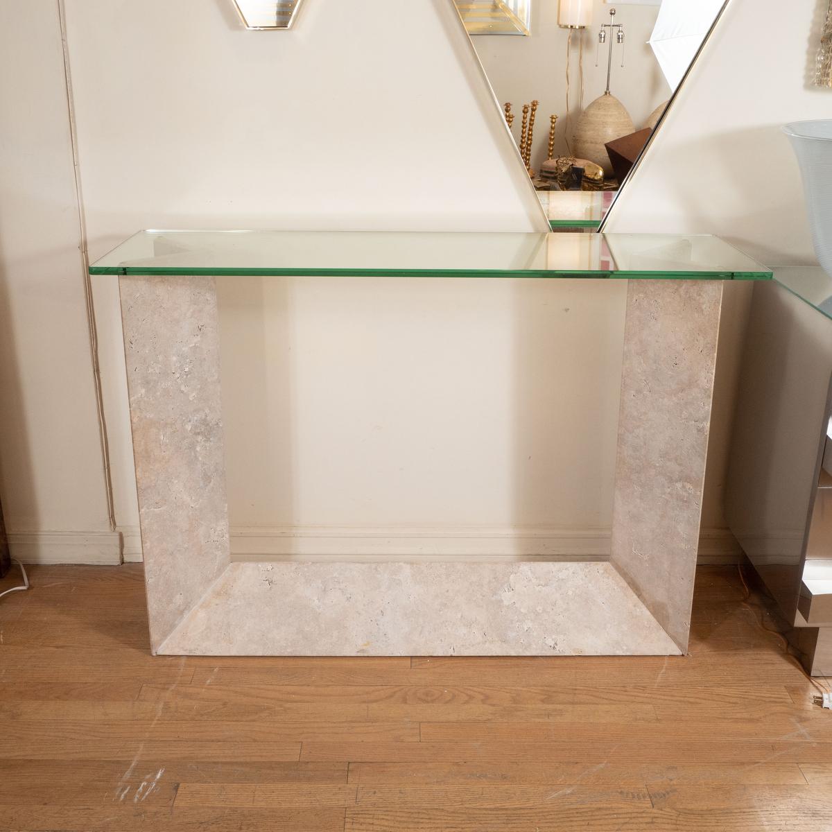 Sculptural travertine console with rectangular glass top.