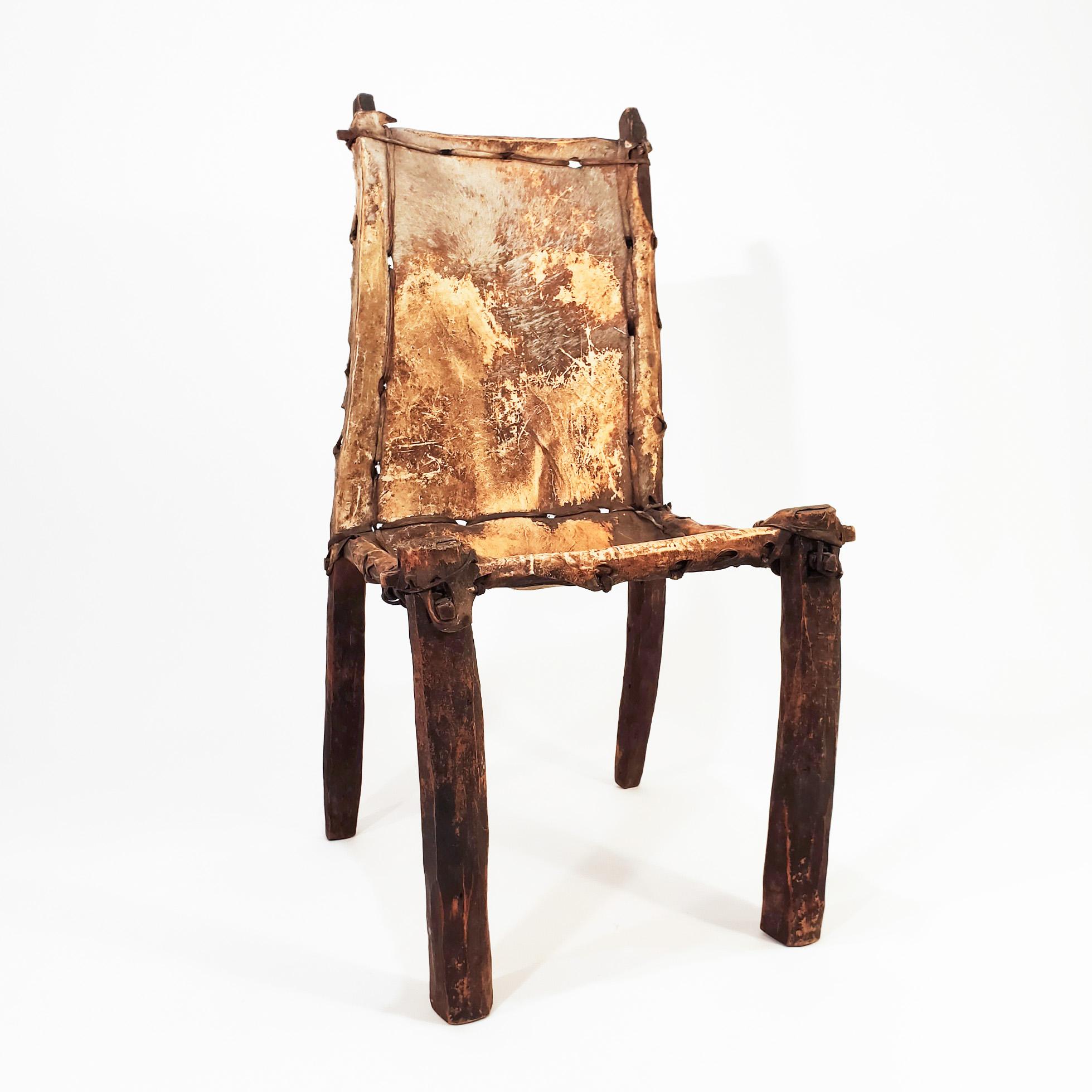 Sculptural tribal chair from Ethiopia in the early 20th century. Made up of pieces of wood joined by archaic fasteners of the same wood and animal (probably goat) leather strips on the seat and backrest. Its use as a chair is good, but it is rather