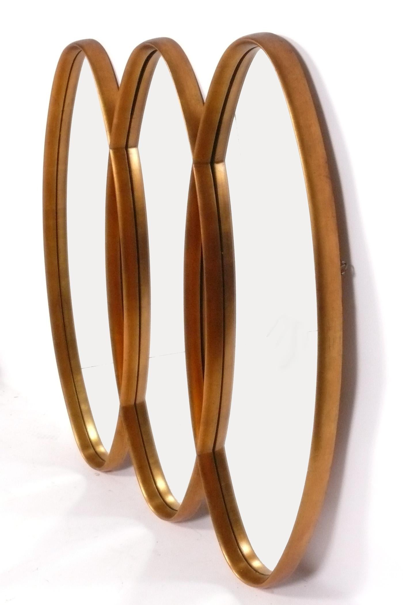 Miroir sculptural triple ovale doré du milieu du siècle, américain, vers les années 1960. Le cadre doré a conservé sa chaude patine d'origine.