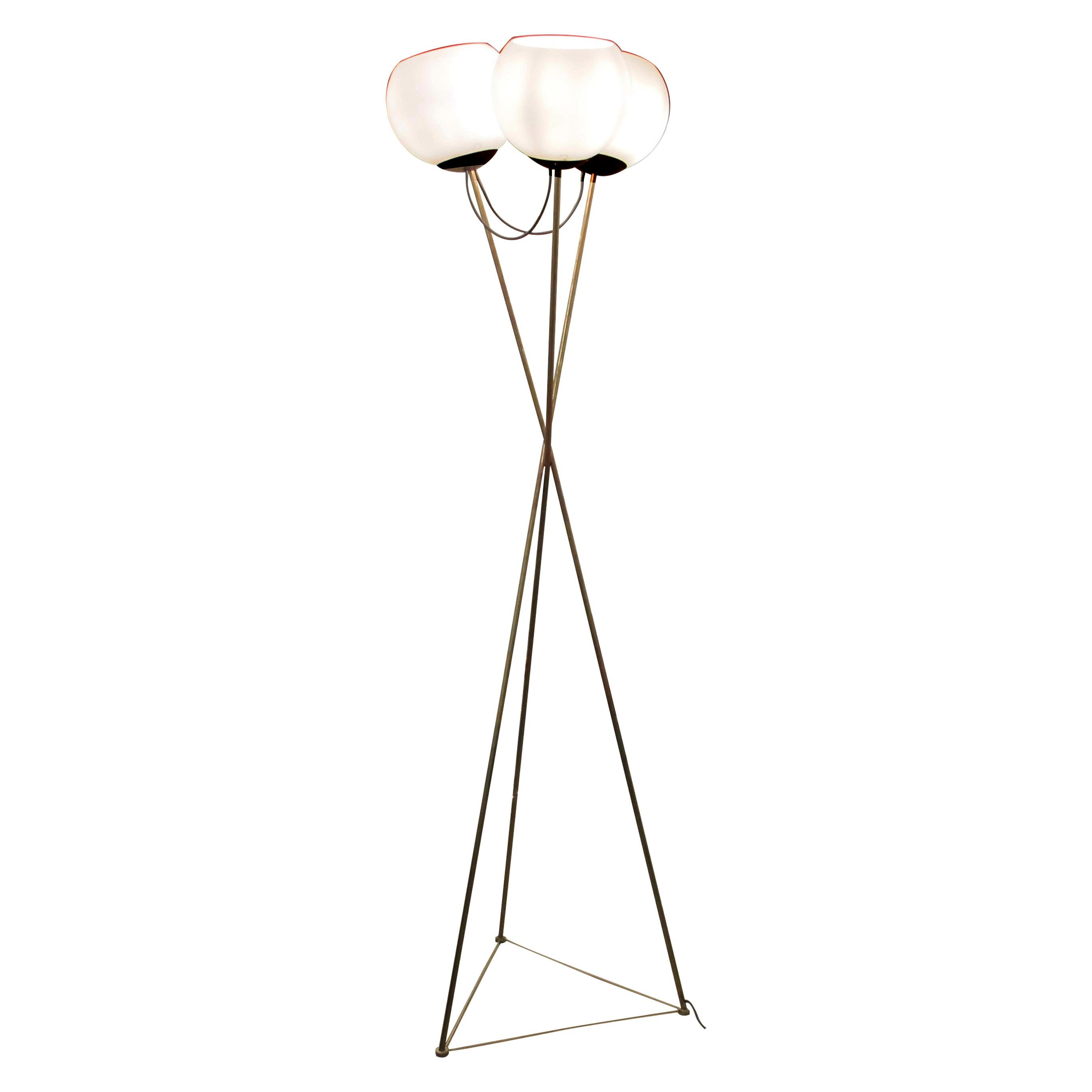 Questa elegante lampada da terra tedesca degli anni '70 presenta una suggestiva base a treppiede in metallo placcato ottone, che culmina in un gruppo di tre globi di vetro opalino. Il suo design senza tempo e la sua luce calda e diffusa la rendono