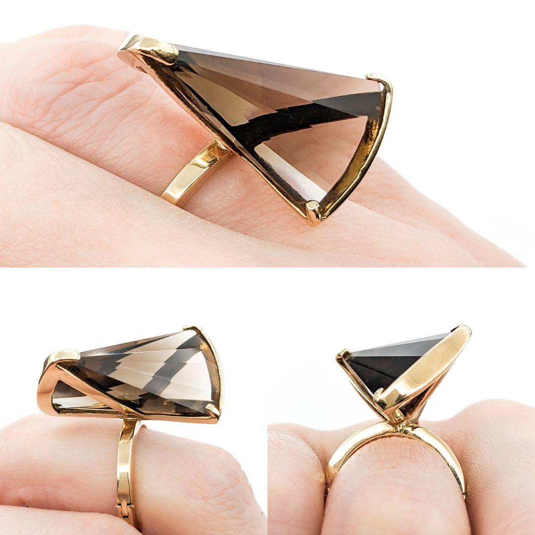 Skulpturaler Rauchquarz-Cocktailring im Drillingsschliff

Entdecken Sie Eleganz mit diesem fein gearbeiteten Ring aus 14 Karat Gelbgold. Sein Herzstück ist ein strahlender 12,5 x 15,5 mm großer Rauchquarz im Phantasieschliff. Der Edelstein glänzt