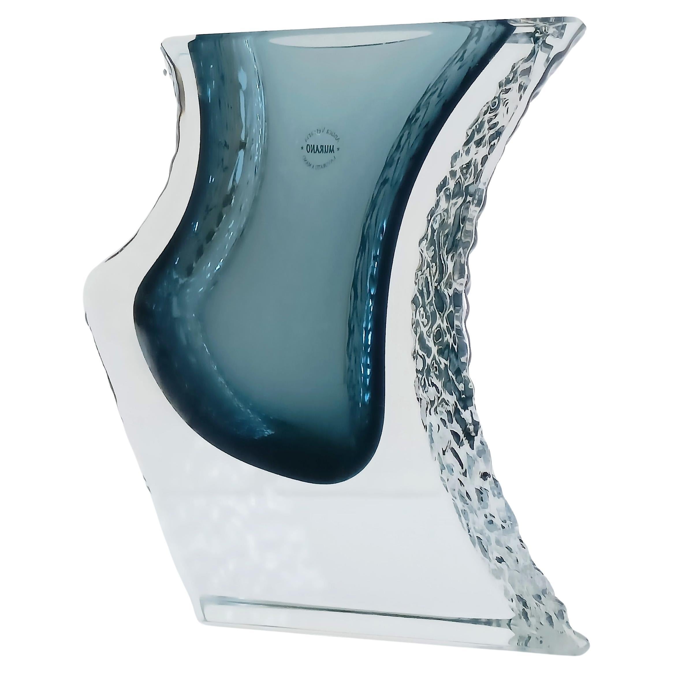 Diese Vase aus Murano-Glas von Sommerso ist ein beeindruckendes Kunstwerk aus der Mitte des Jahrhunderts. 
Die in der klassischen Mandruzatto-Technik handgefertigte Vase zeigt eine gewellte Form mit strukturierten Seiten, die im Kontrast zur Glätte