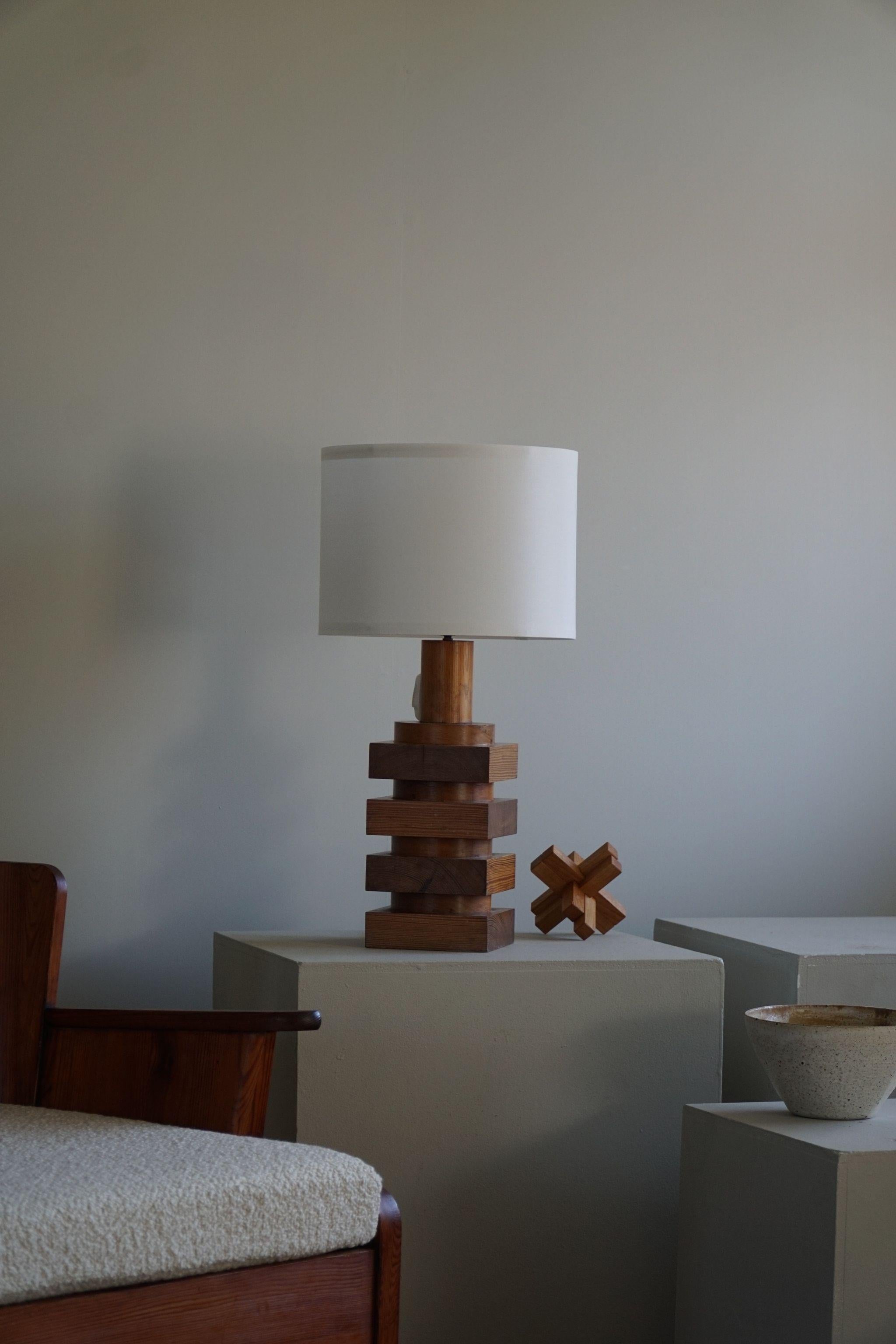 Such a fine sculptural Swedish modern table lamp in pine from the 1960s. The shape and charm in the aged wood of this piece is fantastic. 
The overall impression of these midcentury table lamps is really good.
It will complement many interior