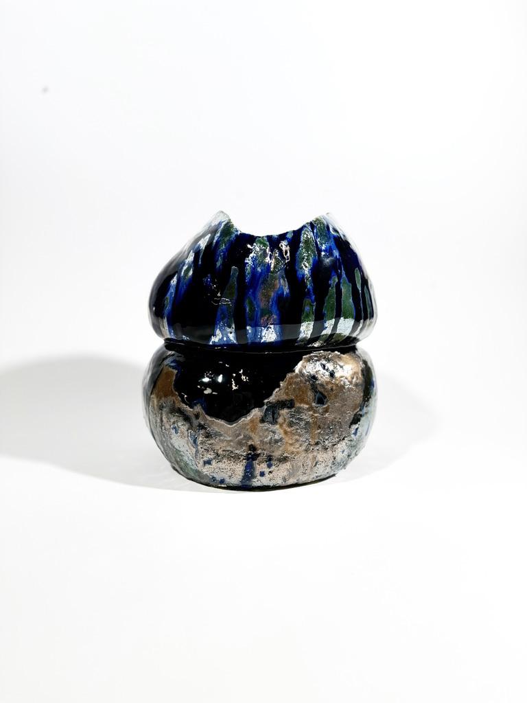 This handmade, one-of-a-kind vase exudes a mesmerising blend of artistry and natural inspiration. Crafted with expert precision, the vase features a stunning dual-layered design. The top half showcases cascading drips of deep blue, accented with