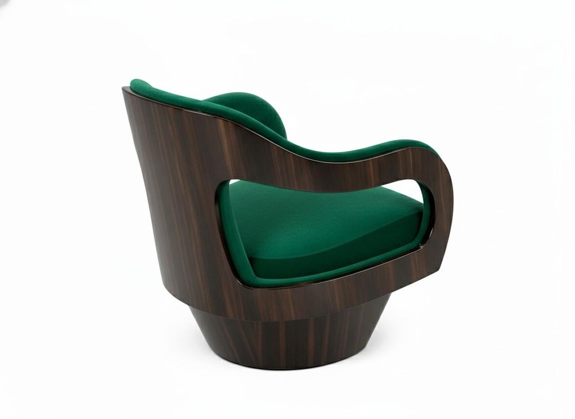 Ce fauteuil luxueux est une étude de courbes élégantes et de matériaux sophistiqués. Il est doté d'une assise rembourrée et d'un dossier enveloppant magnifiquement défini, qui offre à la fois un sentiment d'enfermement et une silhouette gracieuse.