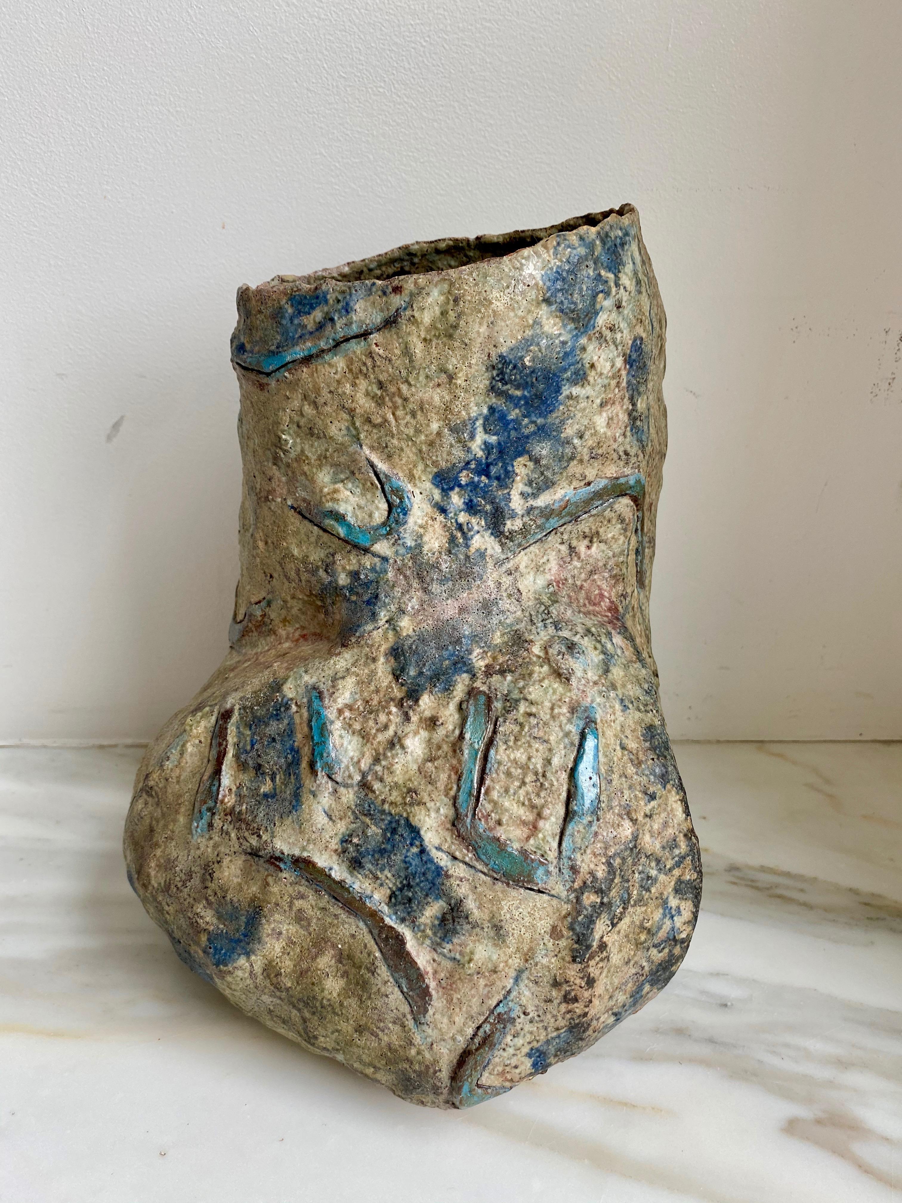 Vasija escultórica asimétrica de gres con superficie rugosa y desigual y símbolos geométricos azules incisos 

Construido a mano por Sara Radstone

Gran Bretaña, década de 1990.