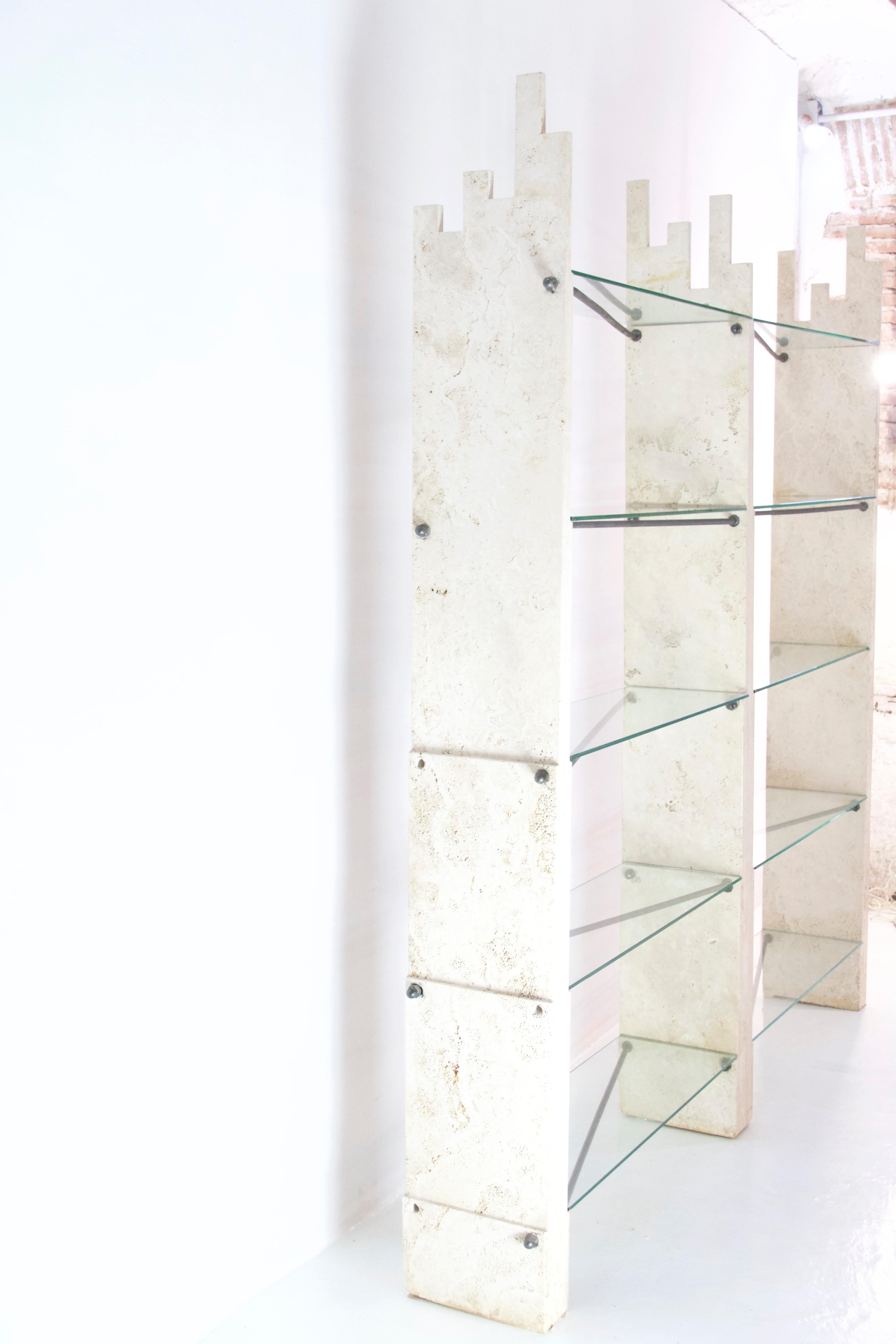 Simply a unique wall unit which has distinct elements of travertine supporting the floating glass shelves. The traverine is supported by steel beams making the constructions sturdy and stable. This bookcase can be modified to either have one large