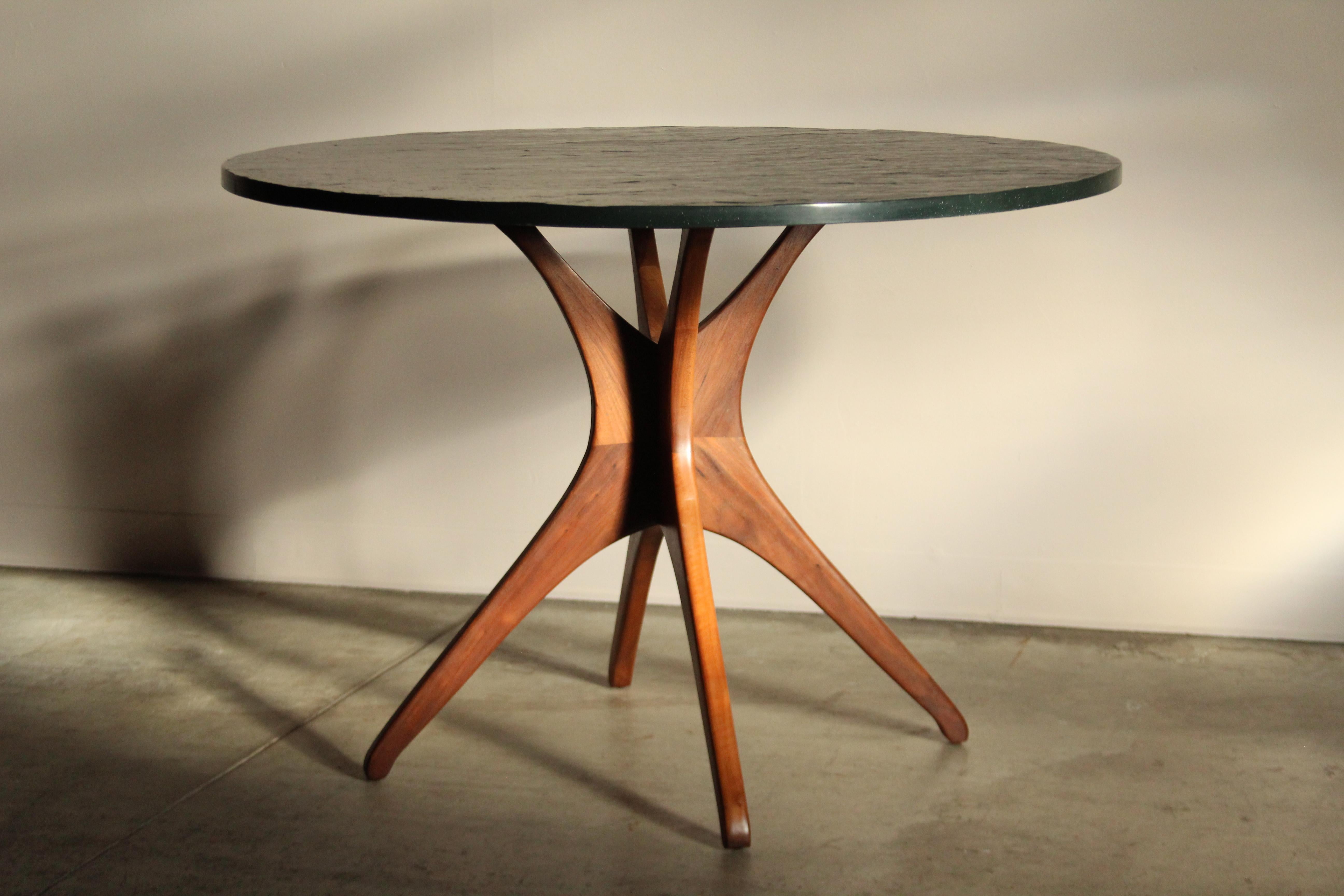 Sculpted walnut and slate dining table made in the 1950s. The table features a sculpted, solid wood base with one inch thick slate top. The slate is black with a greenish tint to it. It is excellent shape without any chips or cracks. The base has