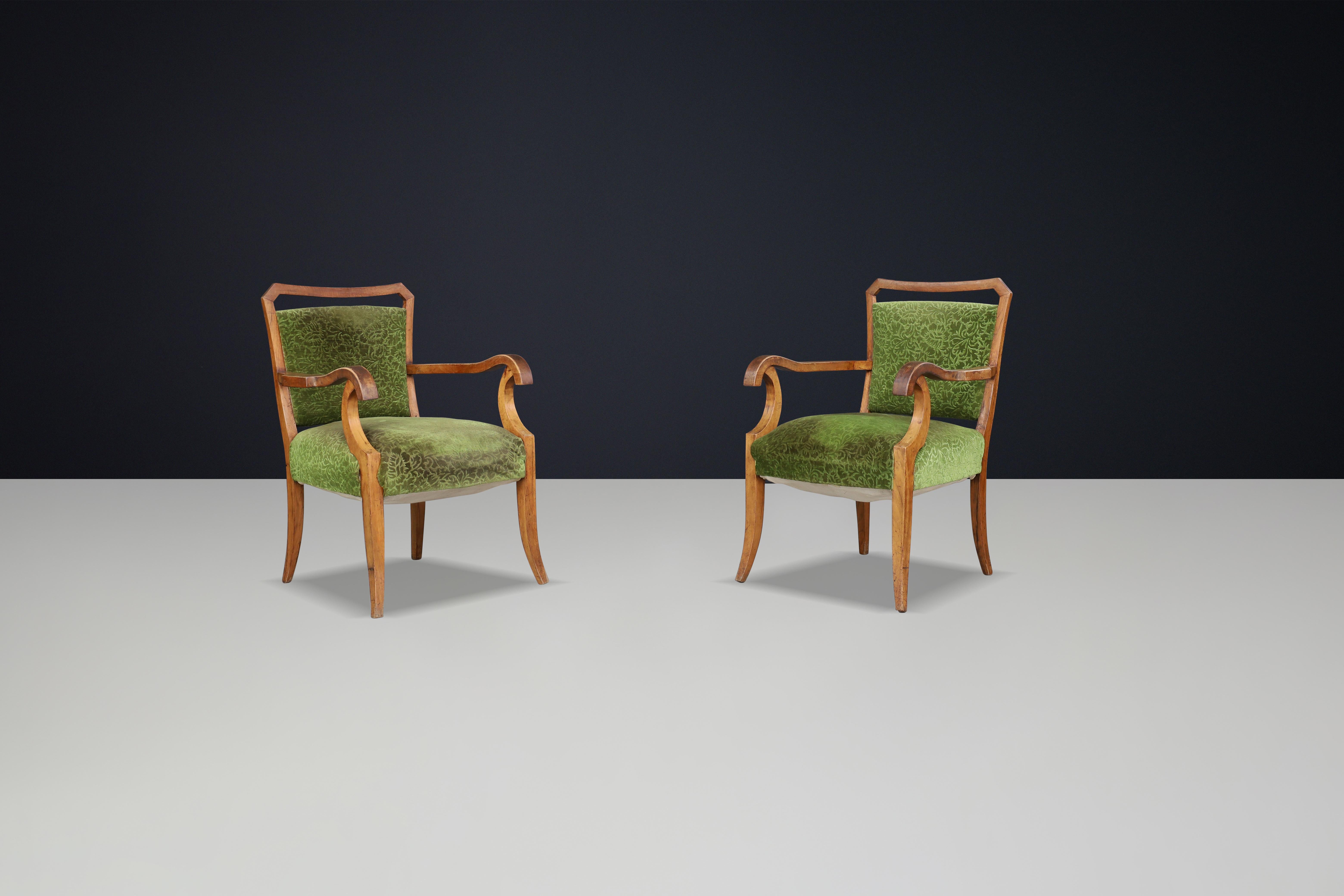 Sculptural Walnut Art Deco Armchairs with Original  green Floral Upholstery, Italy, 1930s

This pair of sculptural Art Deco walnut armchairs, dating back to the 1930s, features original green floral upholstery and showcases a stunning frame and