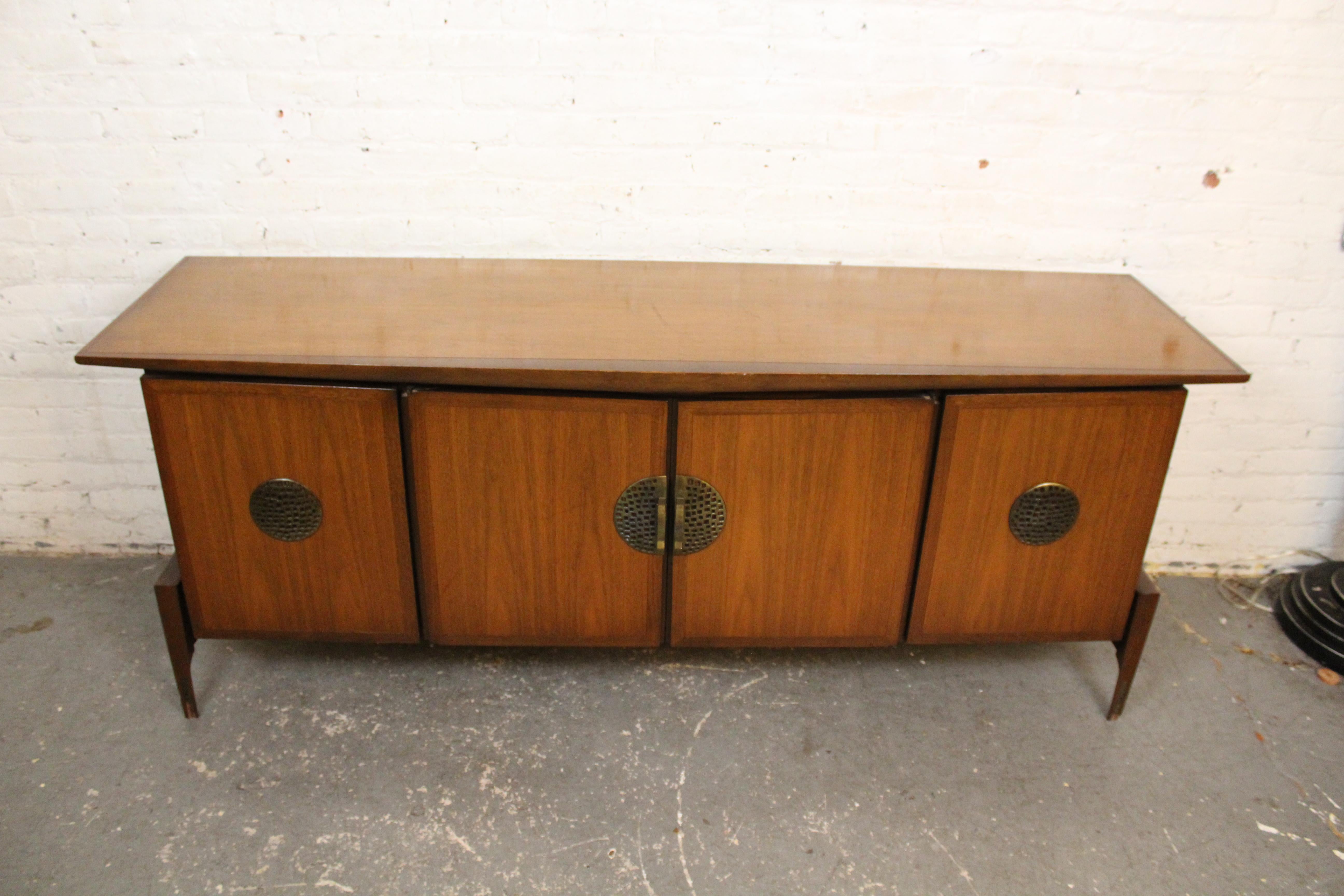 Squisita credenza vintage di metà secolo progettata e prodotta dal marchio Helen Hobey Baker di New York. Una robusta silhouette scultorea mette in mostra una forte influenza cineseria con nove cassetti a coda di rondine sospesi su ampie gambe