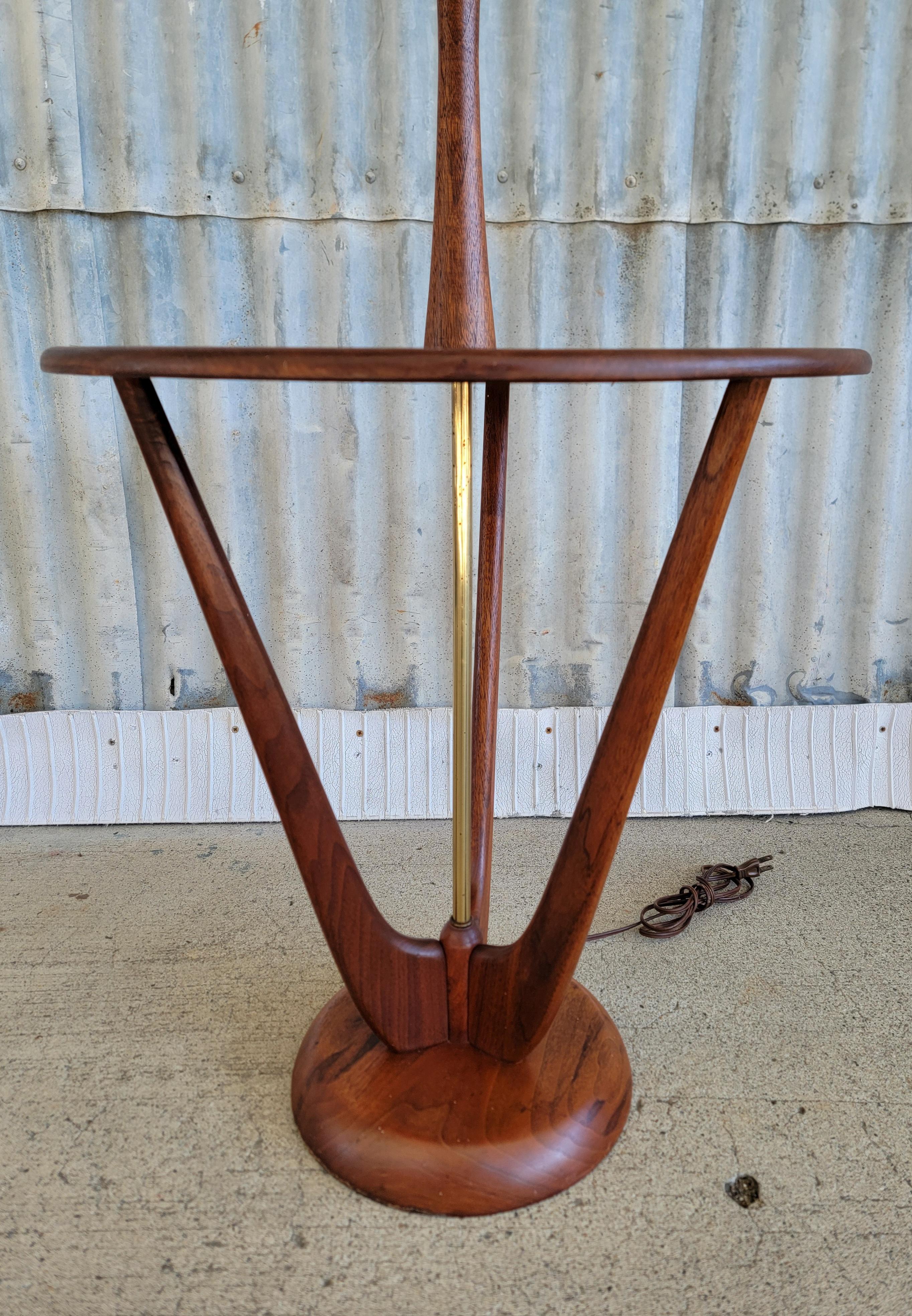 Sculptural floor / end table lamp crafted in solid walnut. In the manner of Modeline Lamp Company. Circa. 1960's. Measures 48.5 in to top of finial. Circular table top measures 20 in high. Original finish. Overall, in very good vintage condition