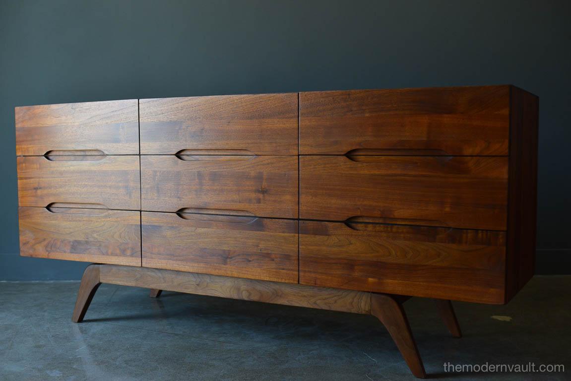 Sculptural walnut nine-drawer dresser or credenza, circa 1965. Solid walnut, not veneer, dovetail drawers and recessed sculpted pulls on a splayed leg base. Gorgeous walnut grain. Excellent original condition with hand oiled finish. Measures 66