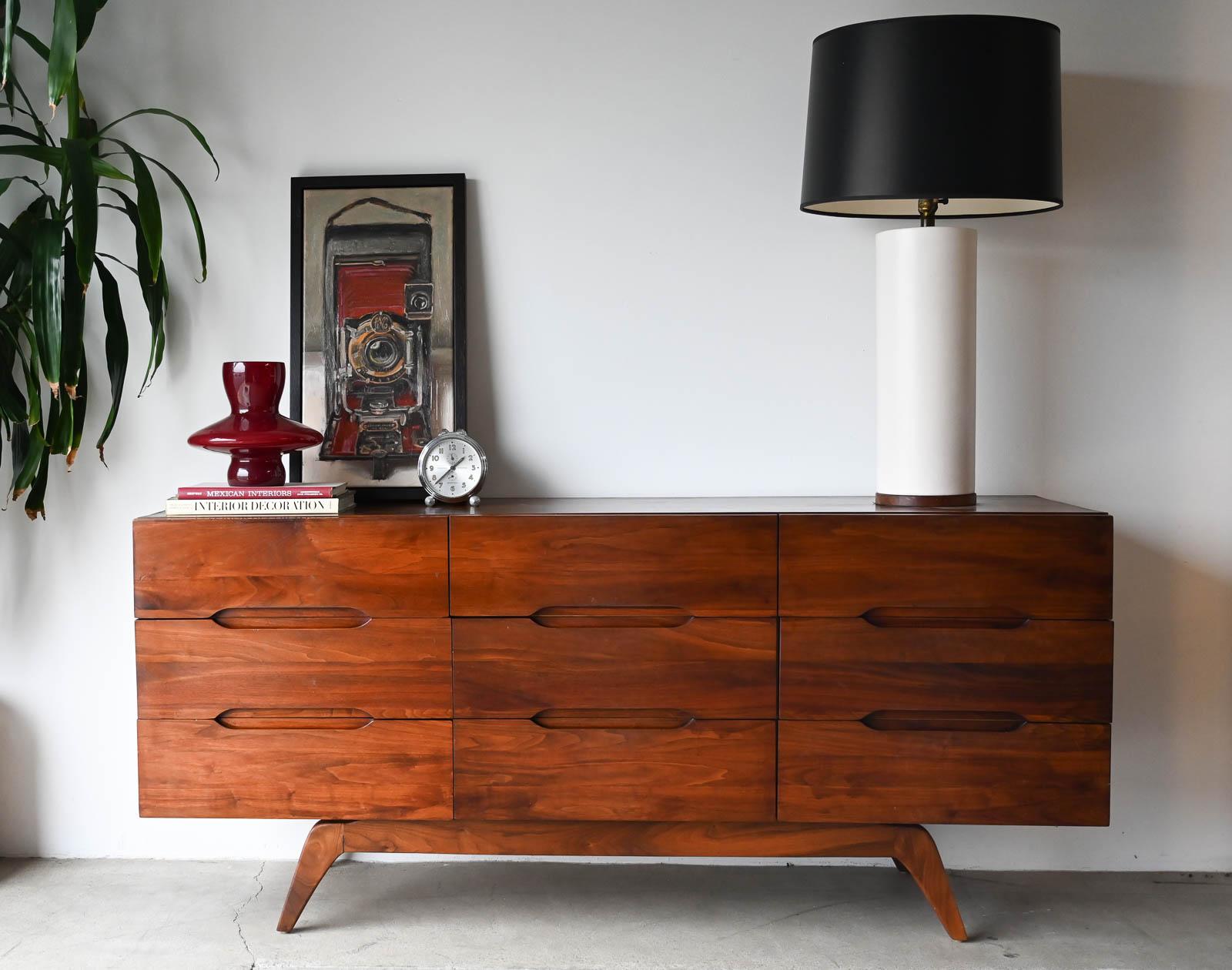 Sculptural walnut nine-drawer dresser or credenza, circa 1965. Solid walnut, not veneer, dovetail drawers and recessed sculpted pulls on a splayed leg base. Gorgeous walnut grain. Excellent original condition with hand oiled finish. Measures 66