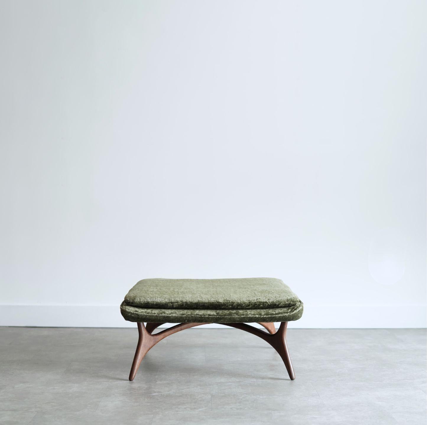 Otomana escultural diseñada por Vladimir Kagan, hacia 1950-1959. Completamente restaurada por Stamford Modern, esta llamativa pieza presenta una base de nogal bellamente esculpida y repintada en un rico tono nogal oscuro. El asiento se ha retapizado