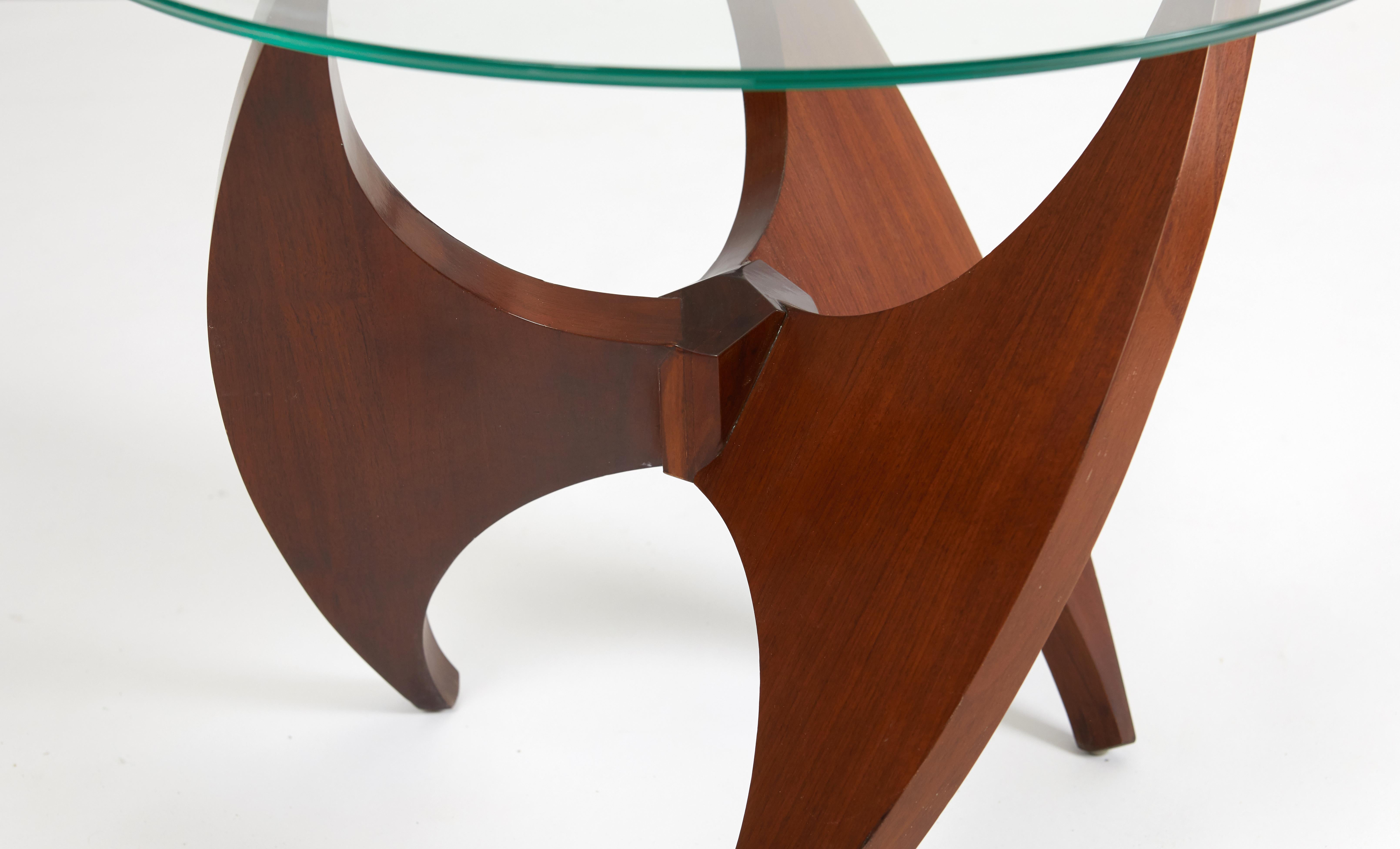 Beautiful solid walnut side table, circa 1950s. Sculptural propeller form base with glass top.