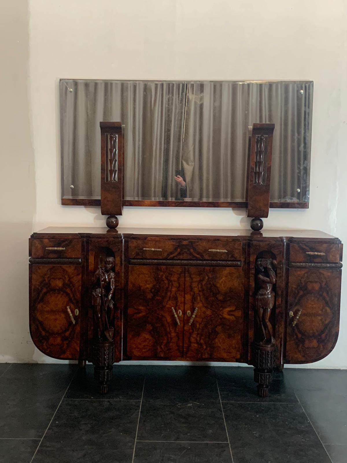 1 of 2 Prestigious Art Deco sideboards with mirror, in walnut and walnut burl on the front it has 2 niches that house masterfully carved sculptures.
On the top it has 1 decorative raised area where a mirror is housed.
Measures: Cabinet H 103 x 20