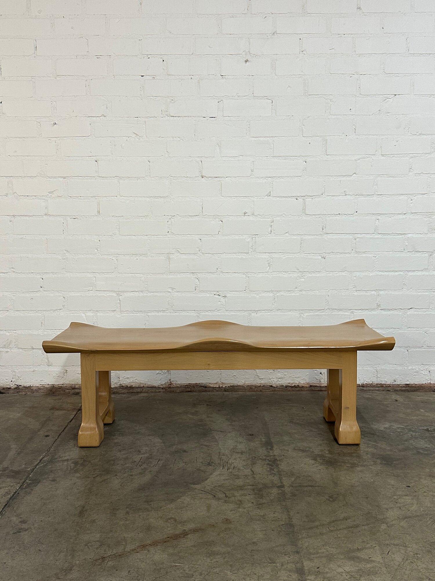 W54 D19 H17.5

Sculptural handcrafted bench made in house. Item is made in solid maple and stained in a light white wash. Item features solid wood construction. This item is made completely in house and can be made in different dimensions and
