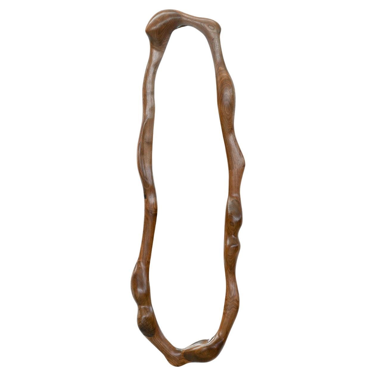 This mirror by Alexander Knysch Studio is a stunning testament to artisanal craftsmanship. Its meticulously hand-shaped frame exemplifies the artistry and precision of time-honored techniques.

Crafted from premium-quality walnut, the wood’s rich