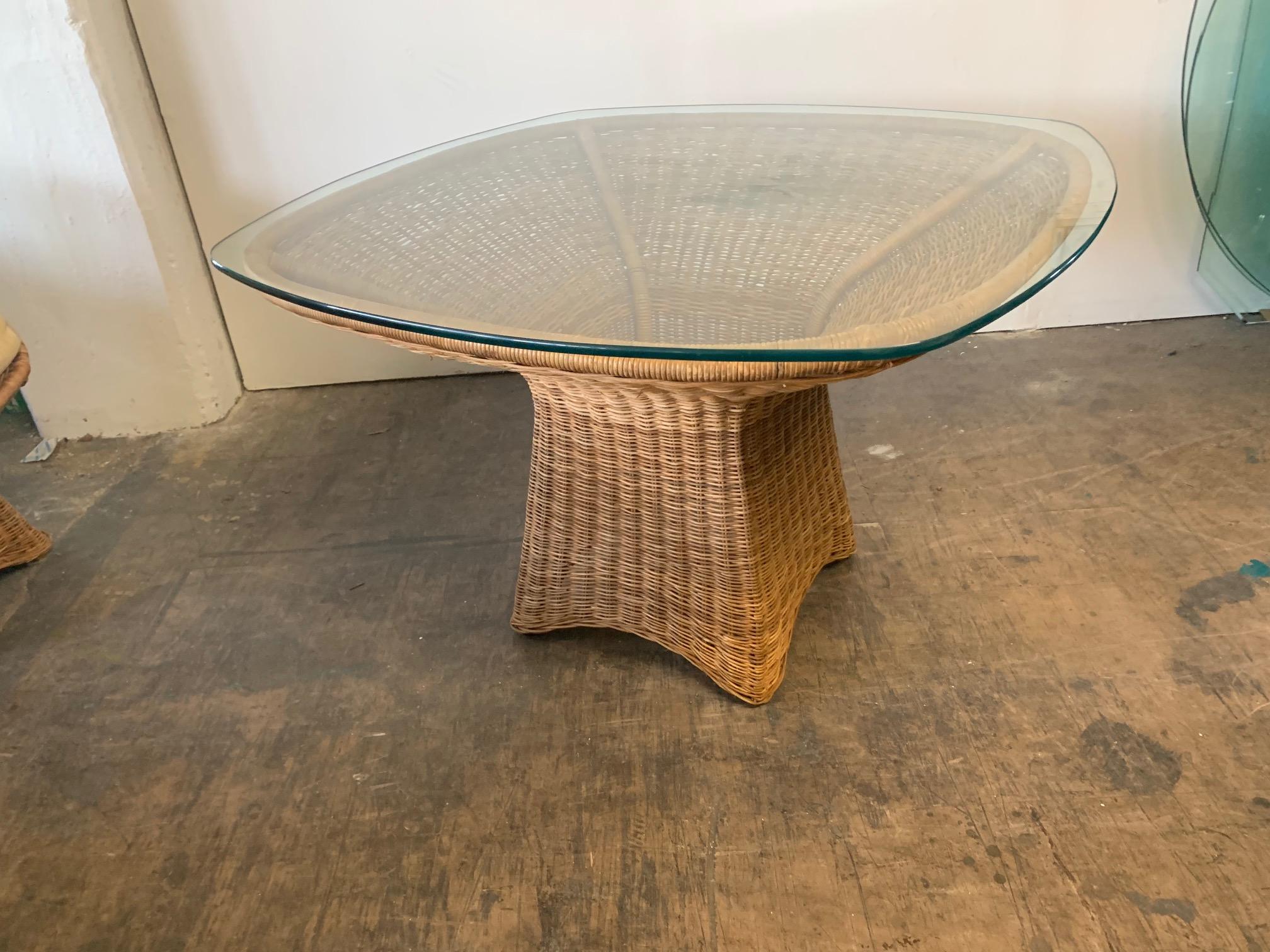 Wicker glass top dining table features unique sculptural form. Very good condition.