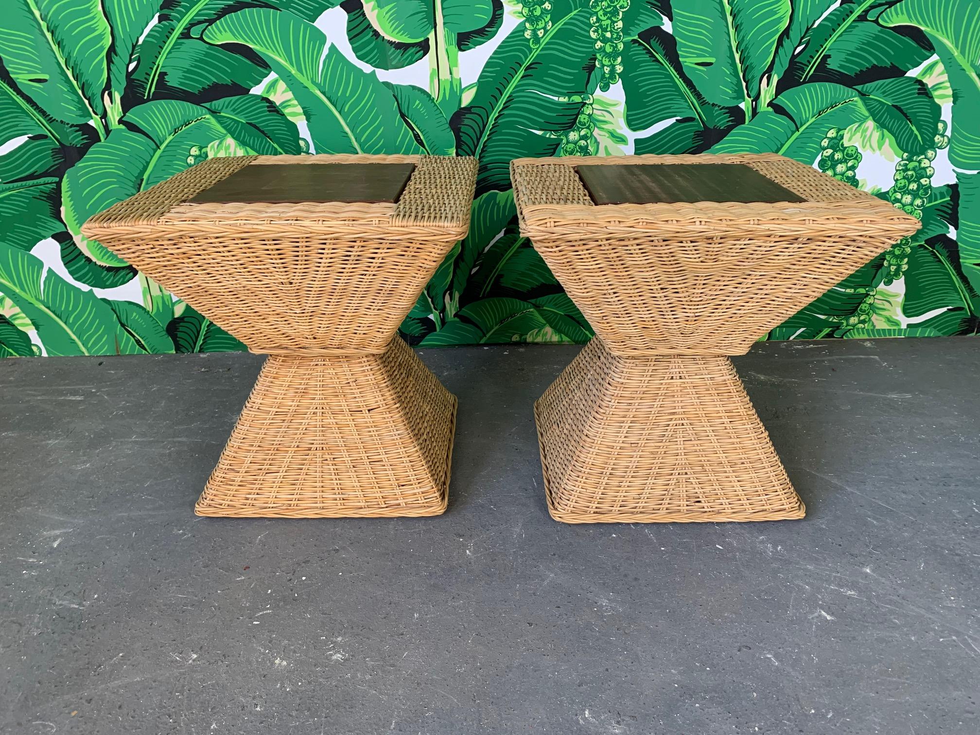 Pair of side tables feature wood frame wrapped in tightly woven wicker with dark stained solid wood tops. Tops can opened for storage space within. Very good vintage condition with minor imperfections consistent with age.