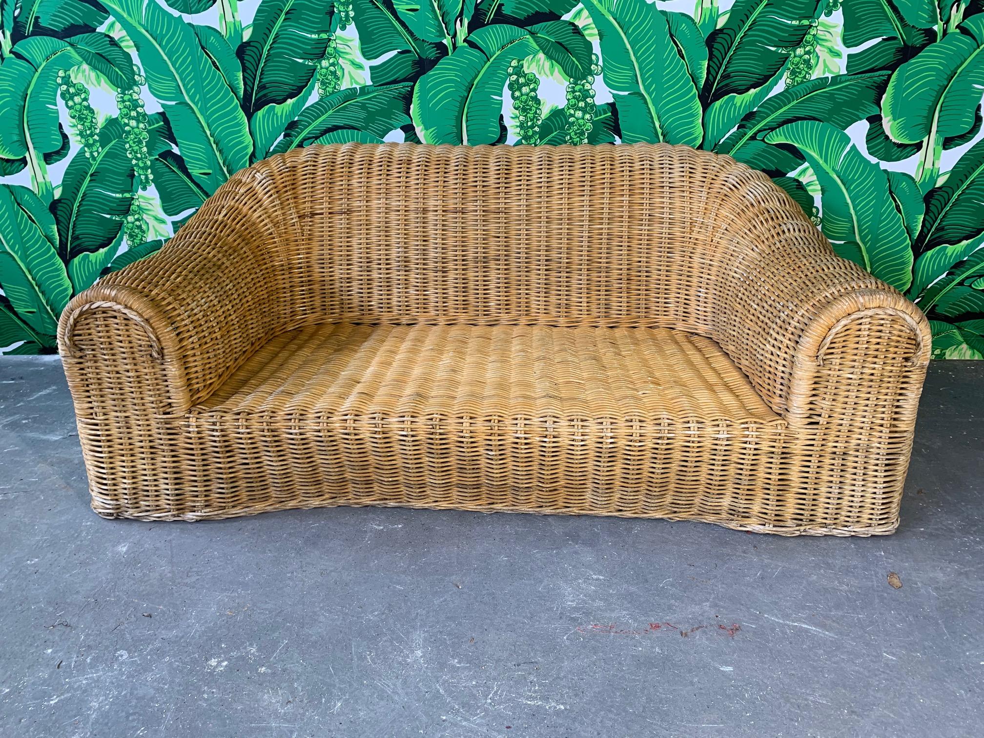 Sculptural wicker sofa in the manner of Michael Taylor or Eero Aarnio. Good vintage condition with minor imperfections consistent with age. Includes cushion (has staining) but no upholstery.