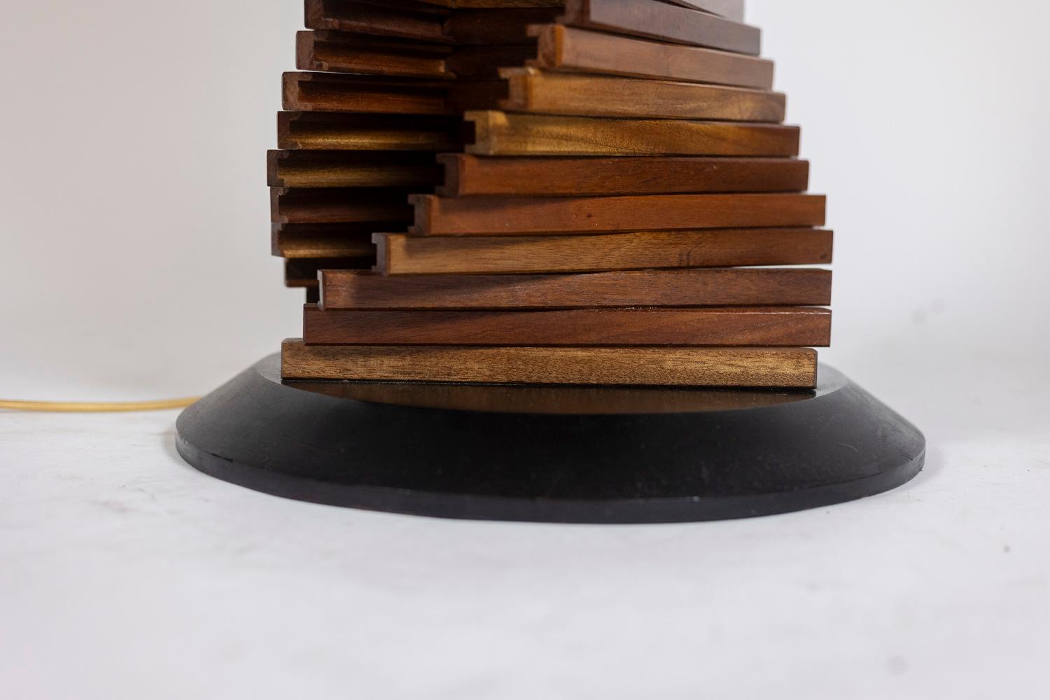 Varnished wooden lamp base, sculptural and abstract in shape, ending in a decorative ball at the top. Circular base in black lacquered wood.

French work realized in the 1980s.