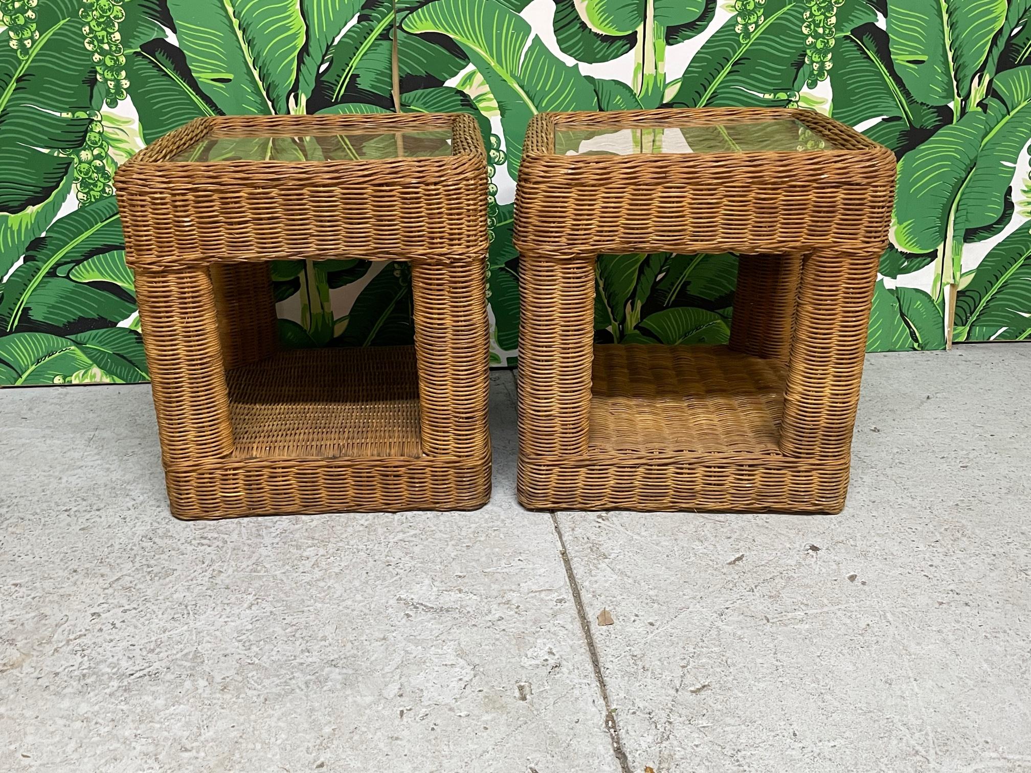 Pair of vintage wicker nightstands feature inset glass tops and intricate woven pattern. Originally purchased in 1970 in the Philippines. Could also be used as end or side tables. Good condition with only minor imperfections consistent with age.