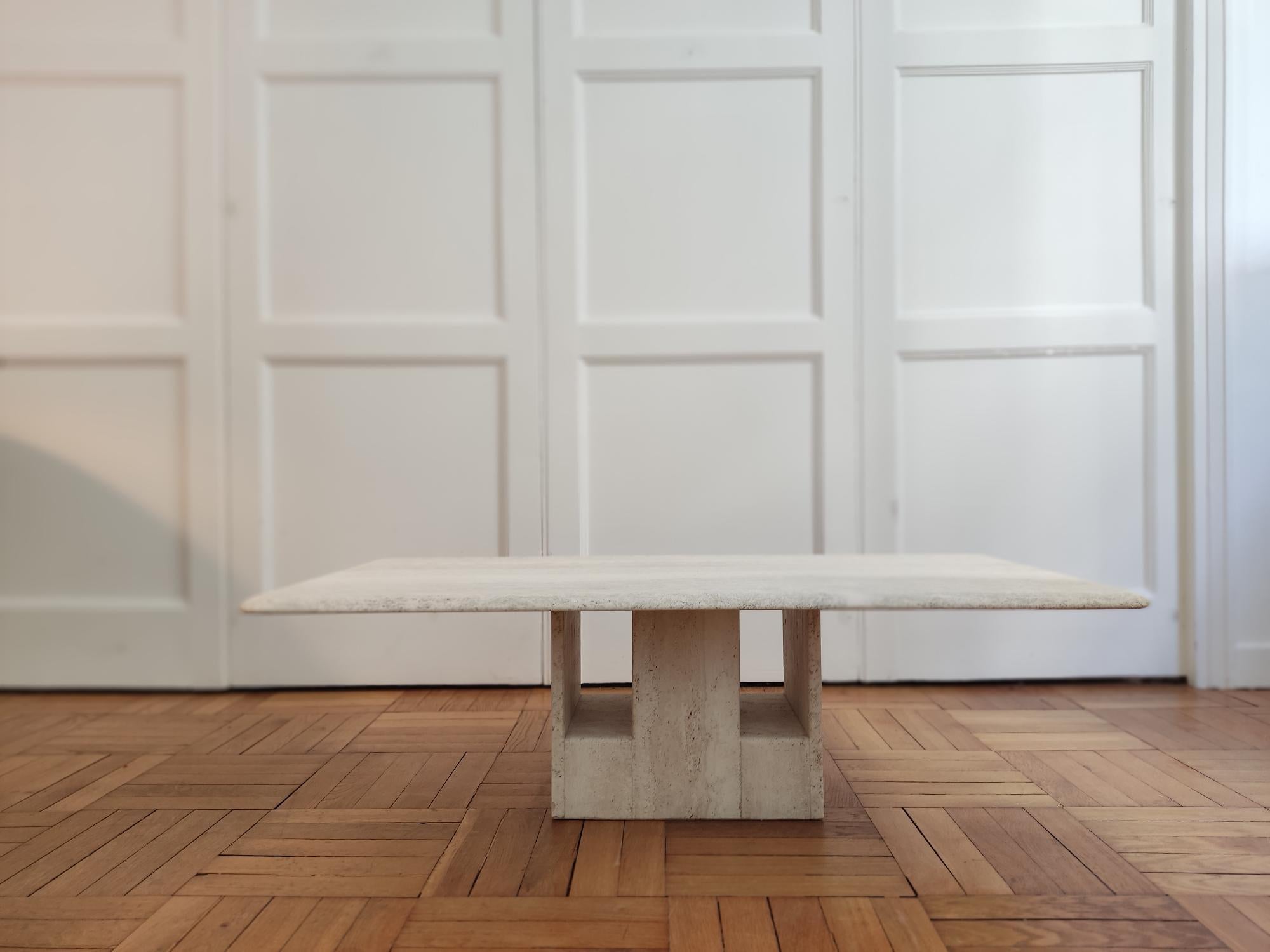 Travertine coffee table. A rectangular top with rounded edges and a sculptural travertine foot. The whole thing is in a single block.
This table comes directly from the designer Claude Berraldacci. They were designed in the 90s. The brand was called