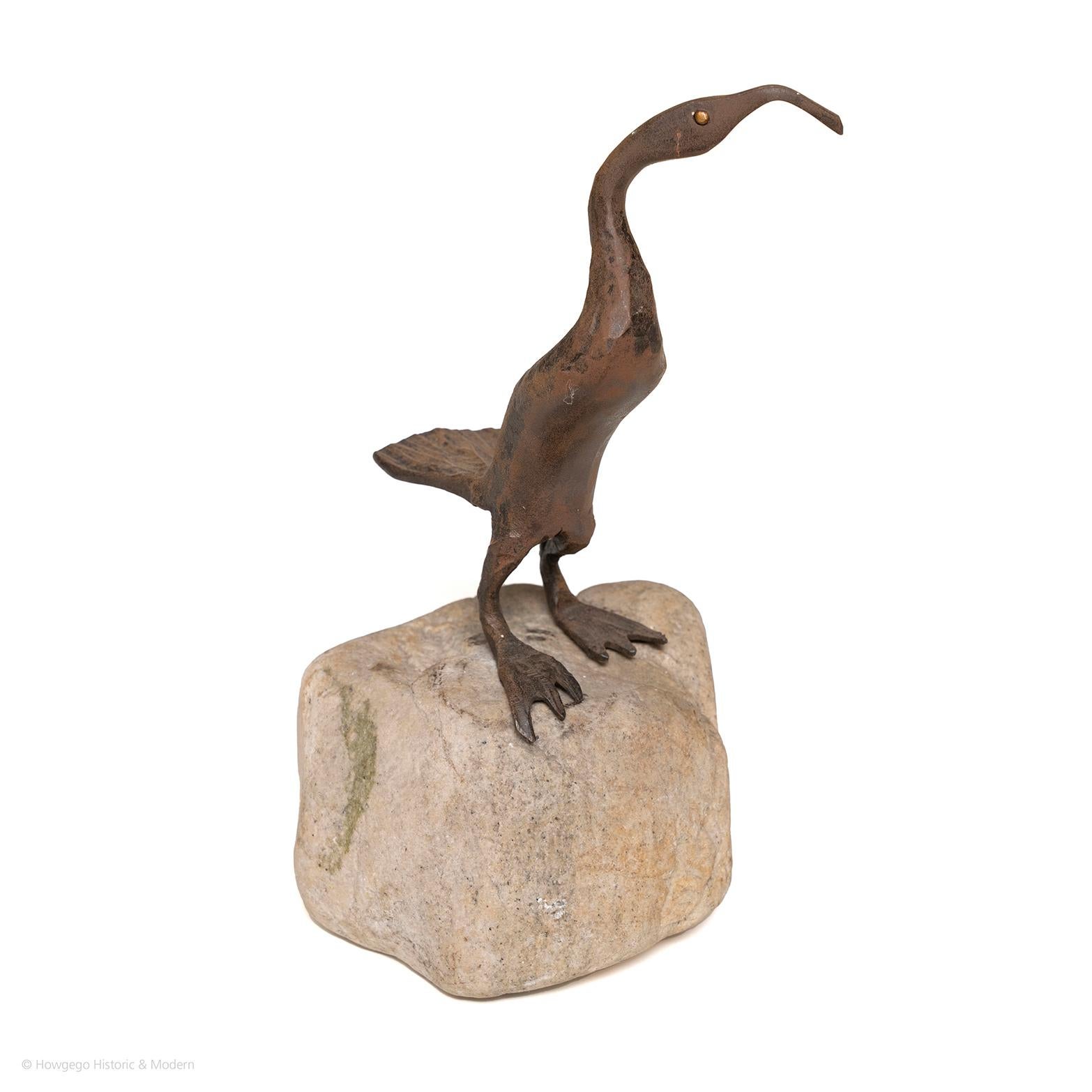 Eine abnehmbare und bewegliche Metallskulptur eines Watvogels, wahrscheinlich eines Brachvogels, mit langem, gebogenem Schnabel, langem, dünnem Körper, dickem Schwanz und breiten Schwimmfüßen.  Auf einem Steinsockel.  Mid-Century Modern