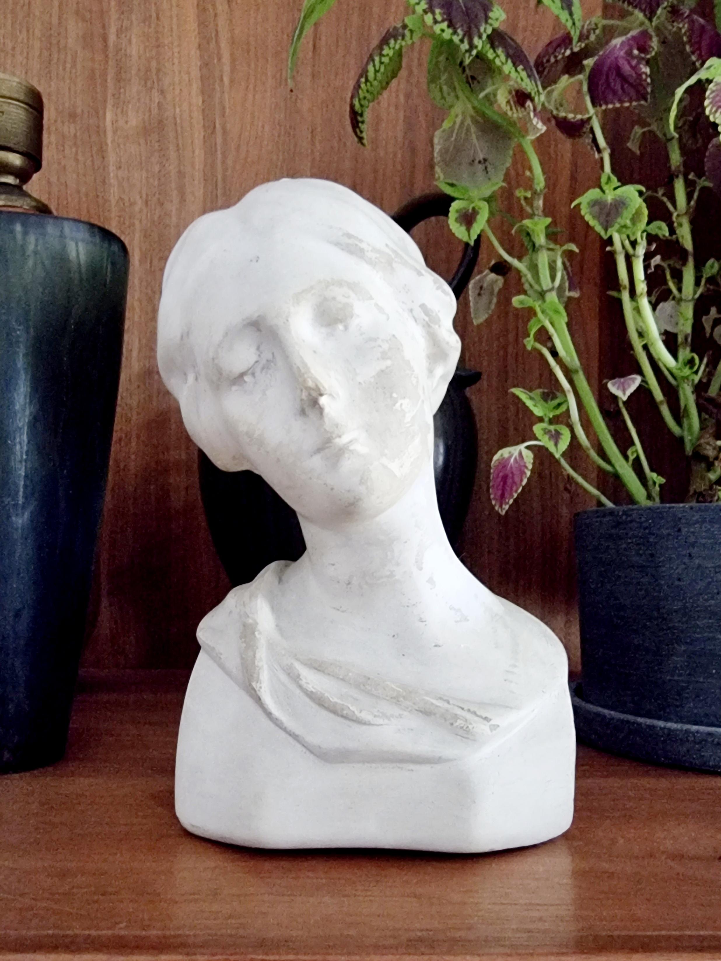 A beautiful bust of a young woman in platser. Signed C. B-L Eneret, 1222. 

Signs of age and patina, damages on nose and dents/scratches and neck with later white coloration, probably a sign of mending. The patina on this bust gives it a strong