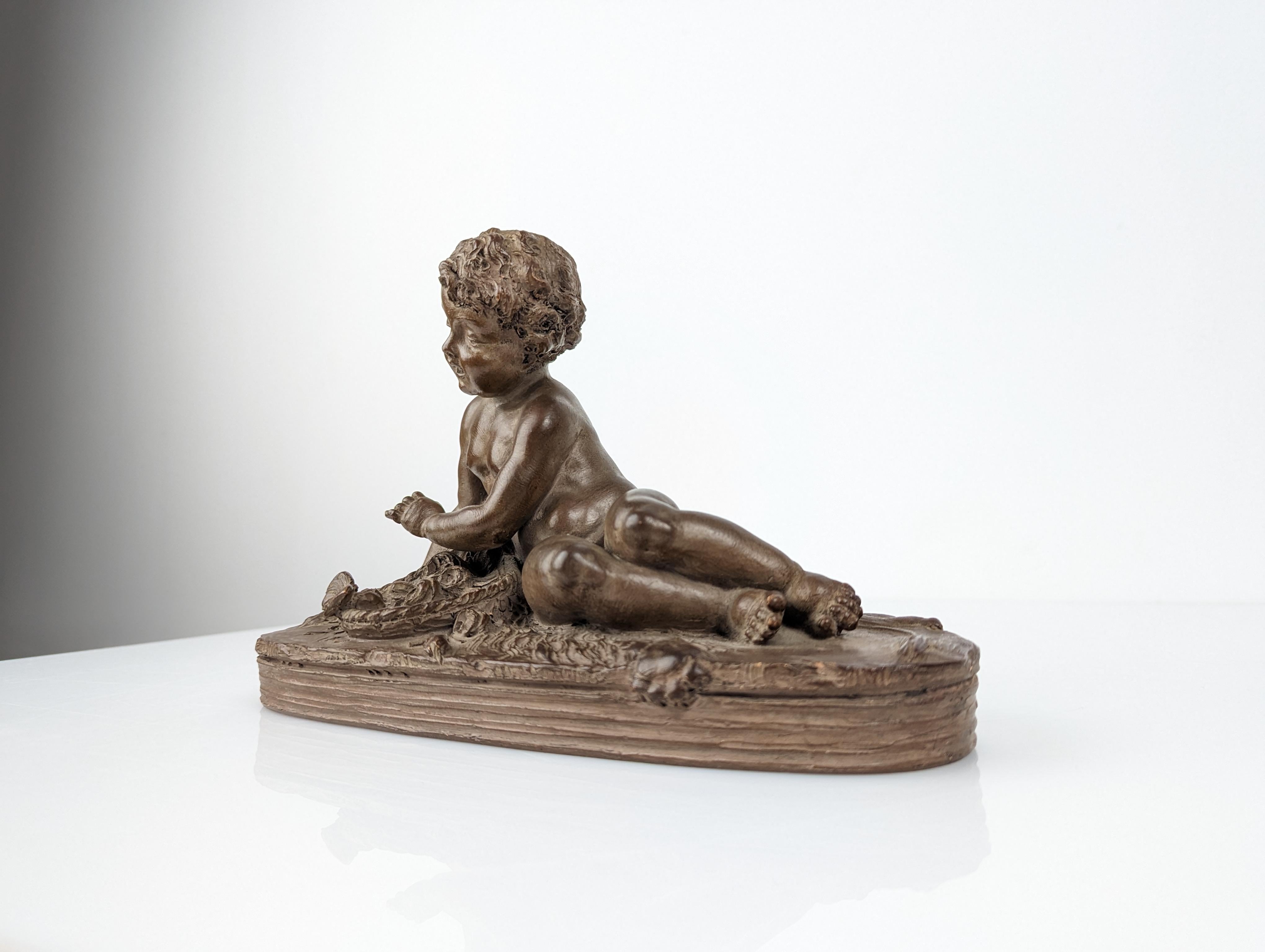 Masterful sculpture by the French artist Renè Rod made in terracotta at the end of the 19th century, sublimely showing us Hercules as a child, lying on a lion skin representing strength. In front of him, a basket with flowers alluding to the beauty