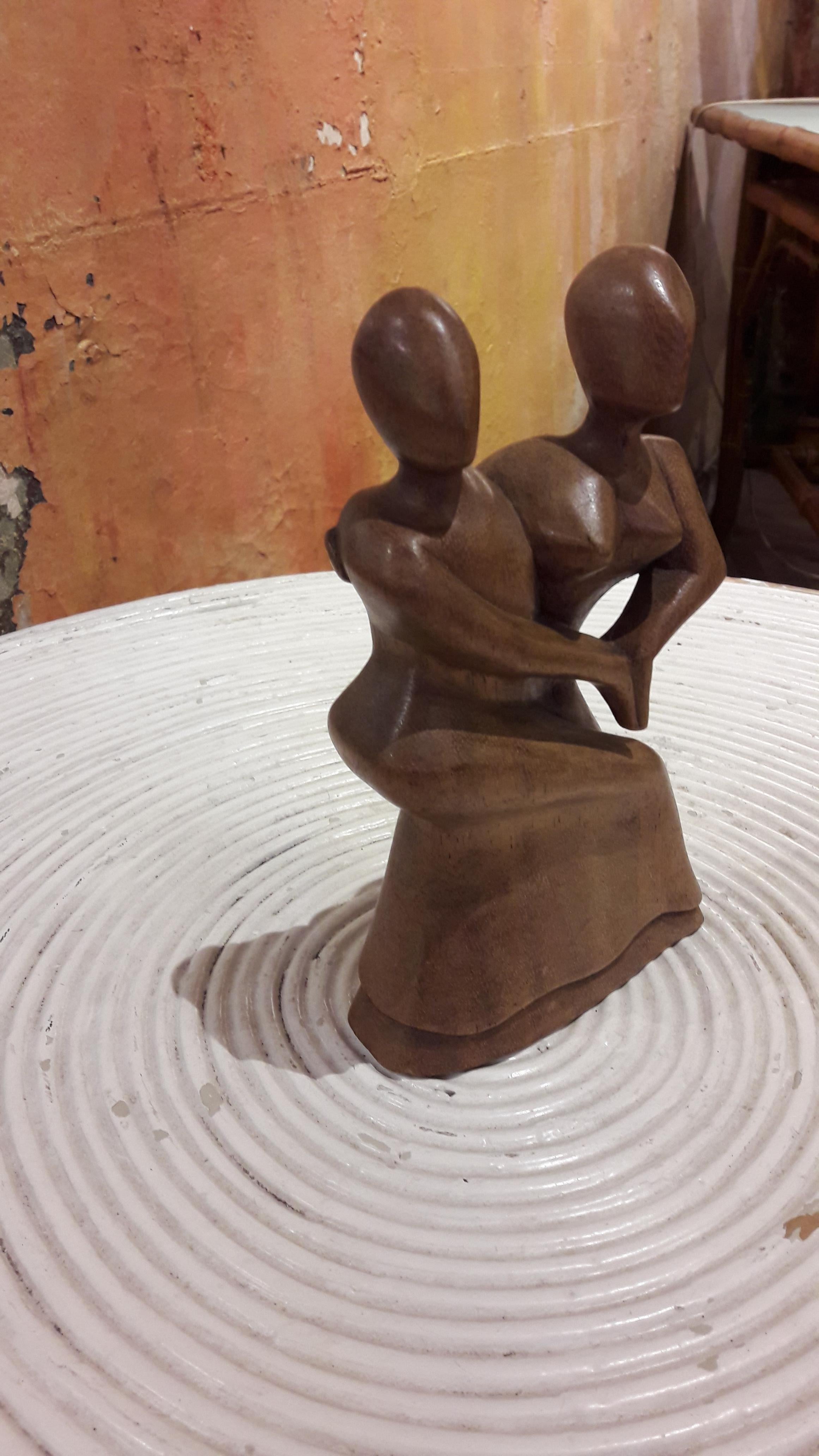 Decorative small teak statue of a dancing couple.