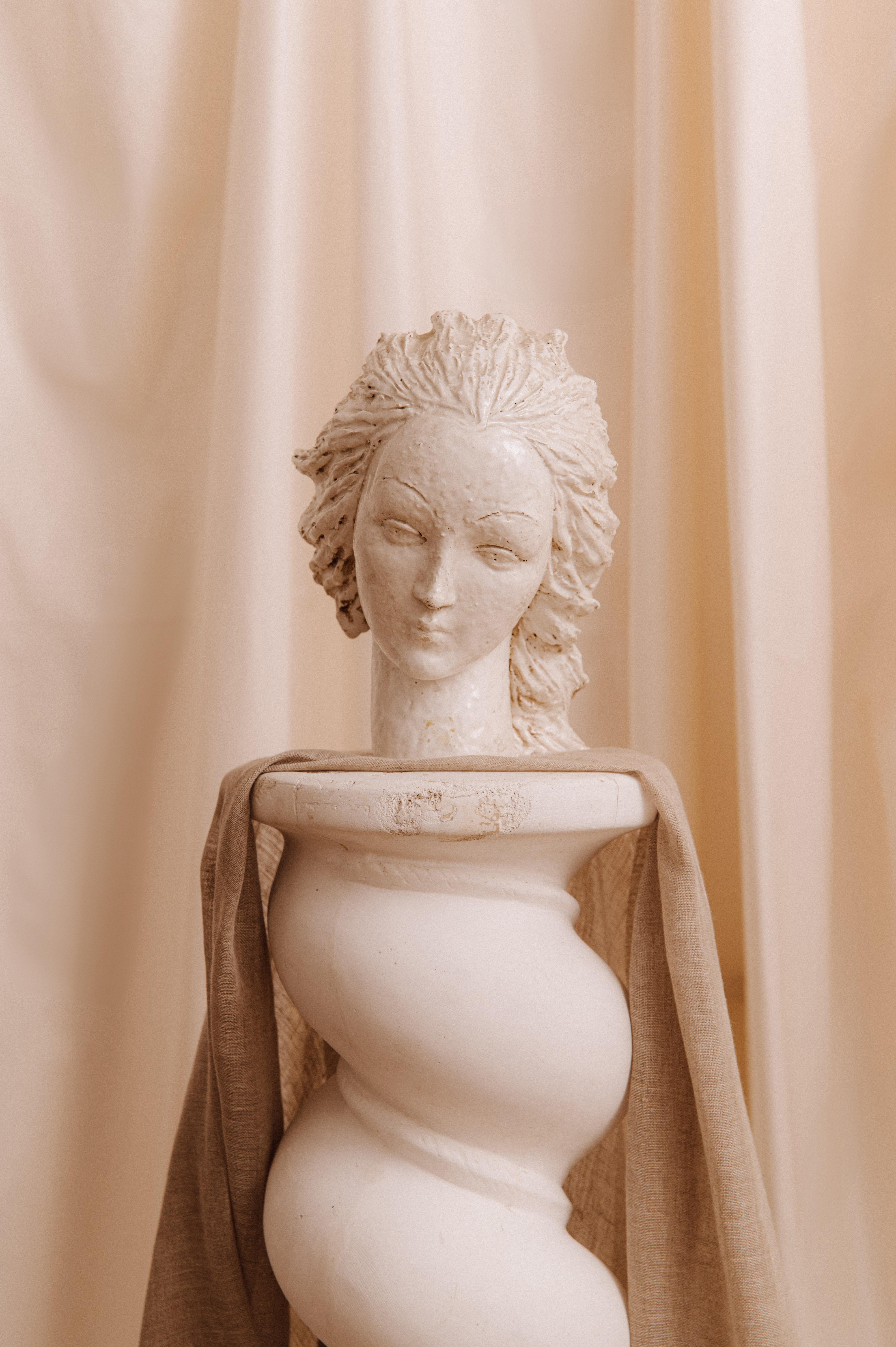 Esta escultura, firmada Eugenio Pattarino, representa un busto femenino de rasgos delicados y expresivos, que ilustra el saber hacer excepcional del artista italiano. La textura fina de la textura parece captar un movimiento, aportando dinamismo y